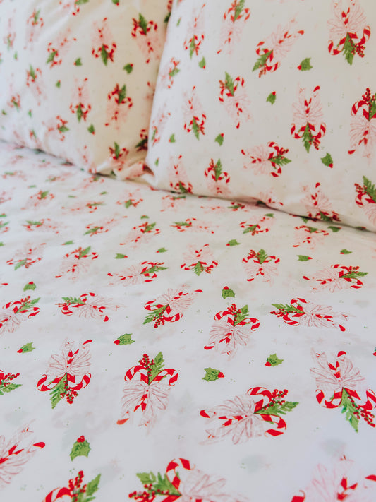 Holiday themed sheets and pillow cases on made up bed. 