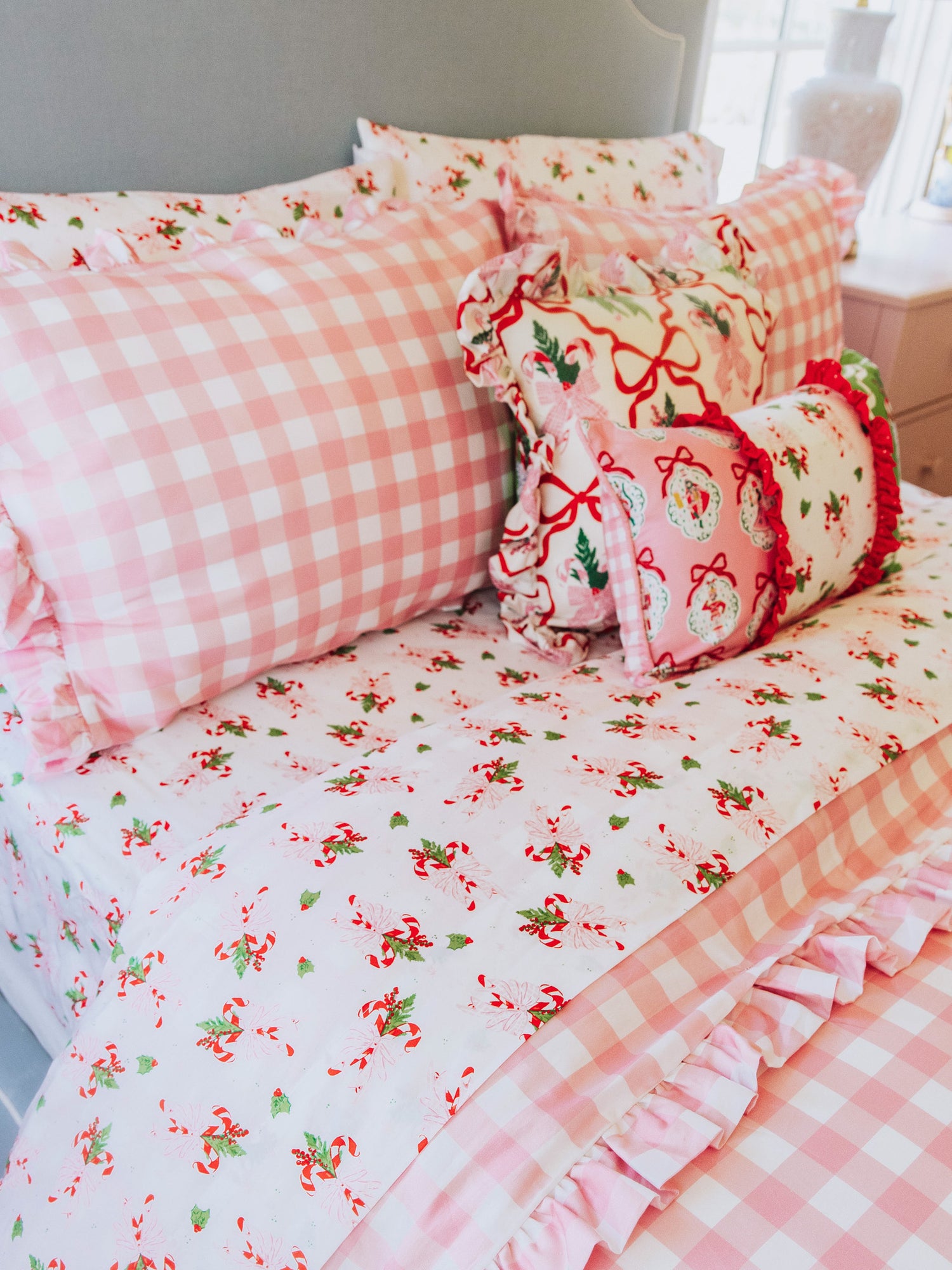 "holiday themed bedding with pink gingham print and other matching holiday prints