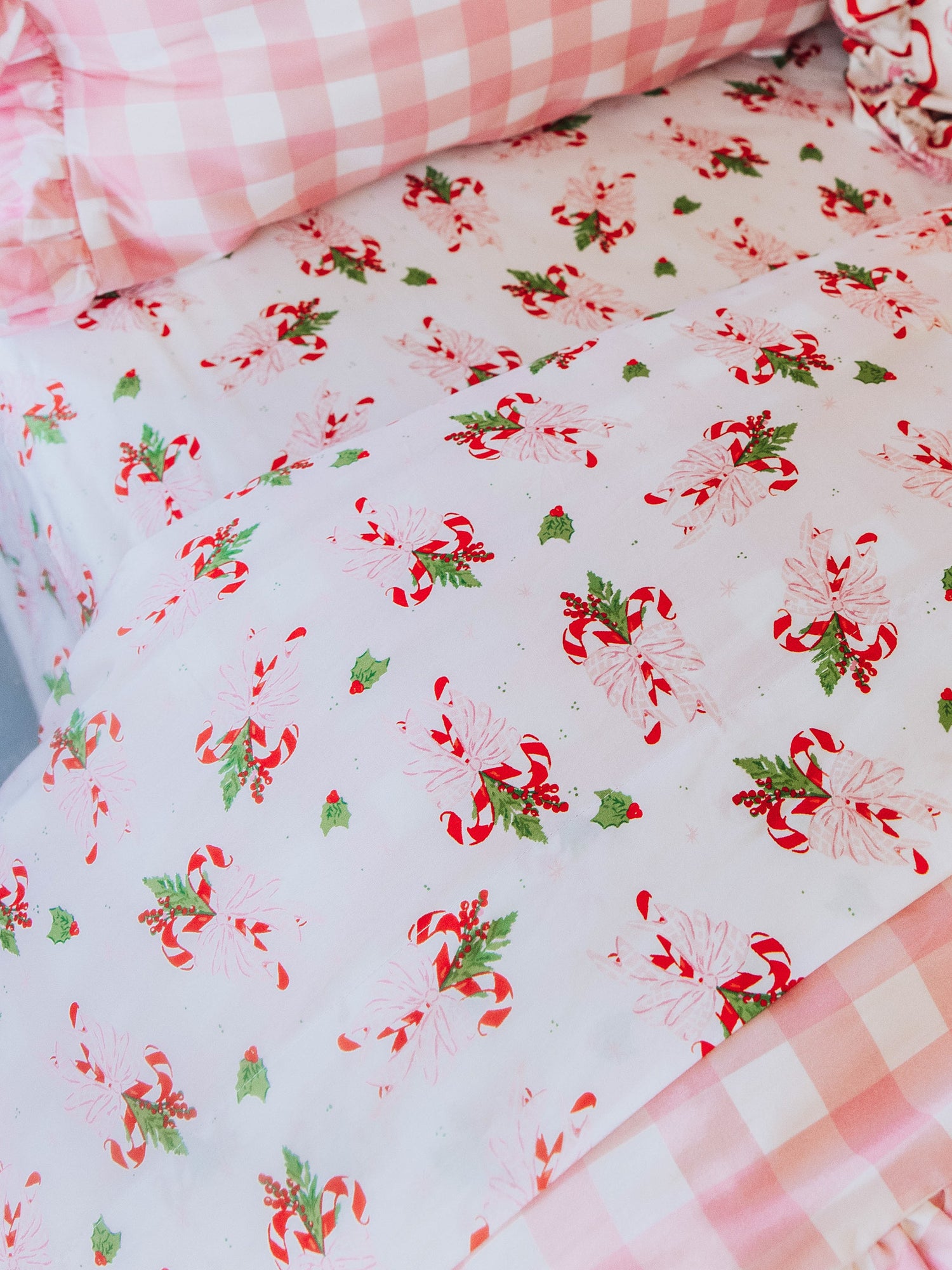 "holiday themed bedding with pink gingham print and other matching holiday prints