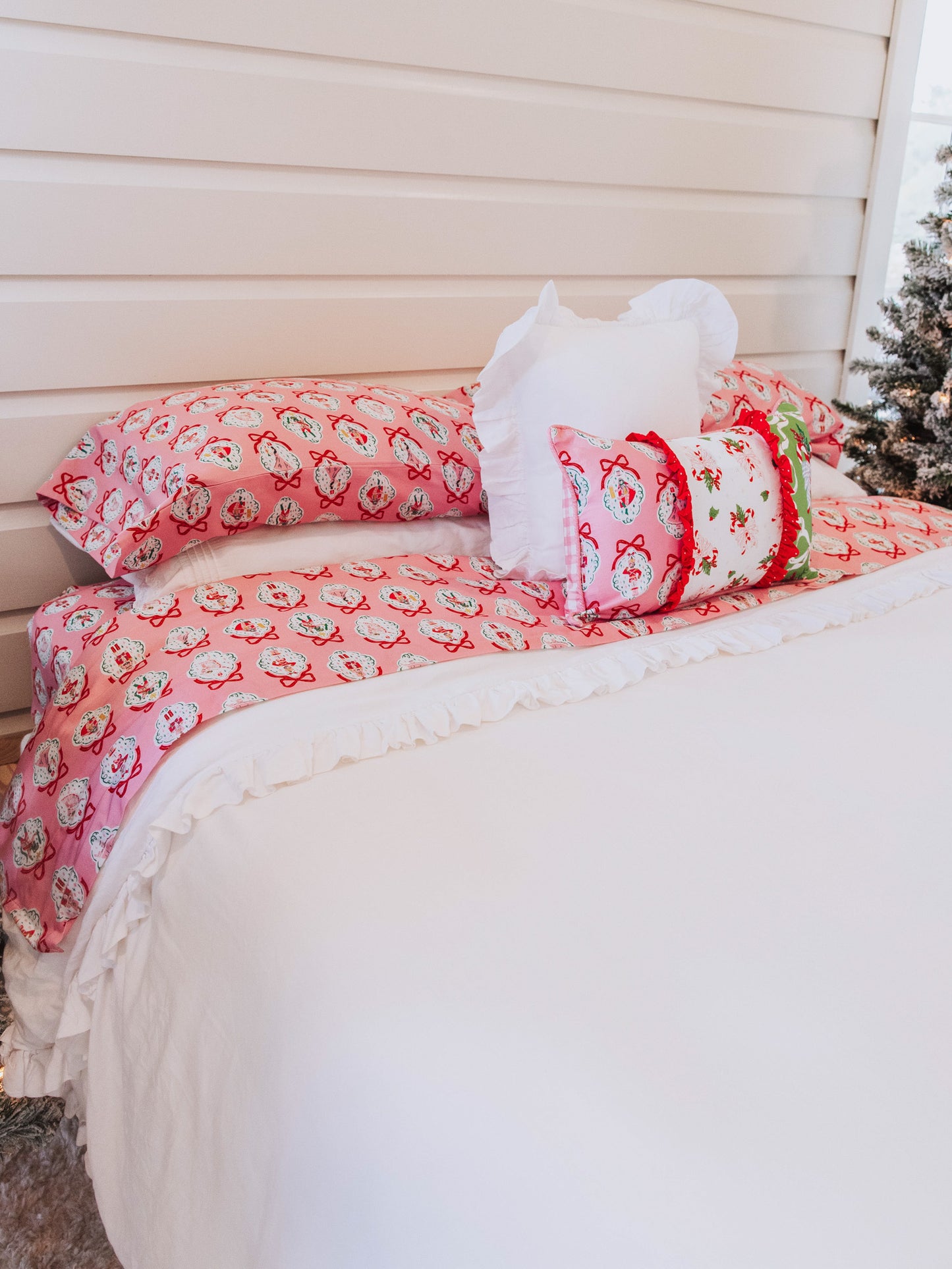 Pink nutcracker sheets with decorative pillows and white duvet cover. 