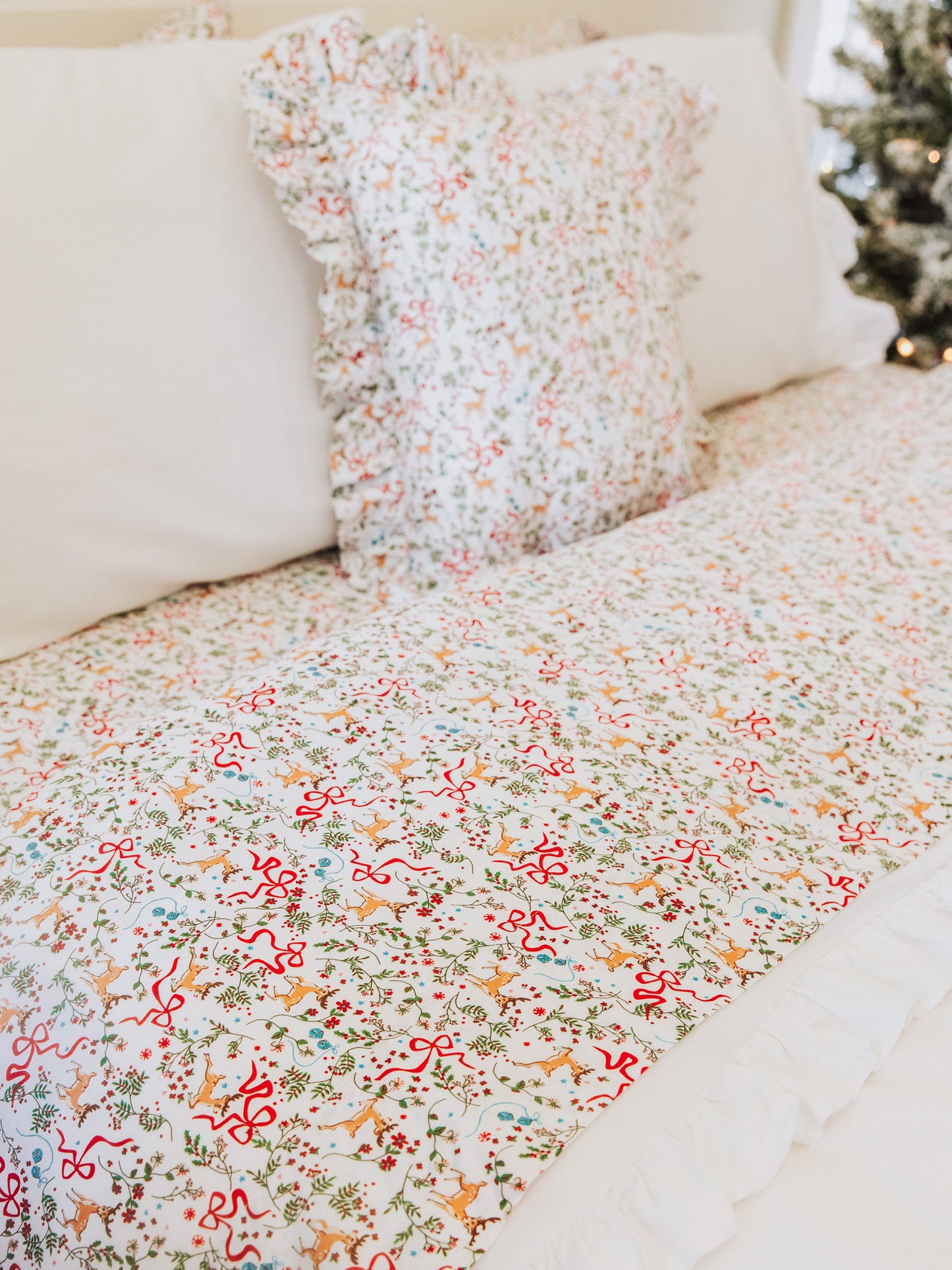 Holiday themed decorative pillow and sheet set with white pillows and duvet. 