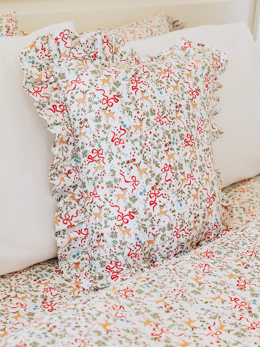 Christmas themed pillow shown with matching themed sheets. 