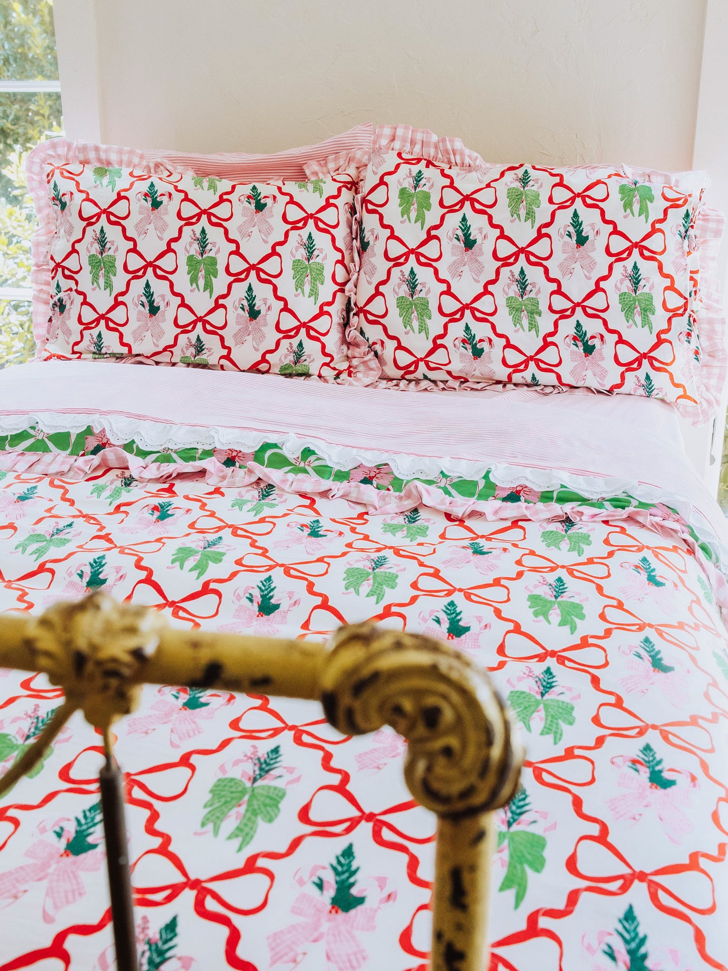 Christmas themed bedding shown with pink lace trimmed sheets. 