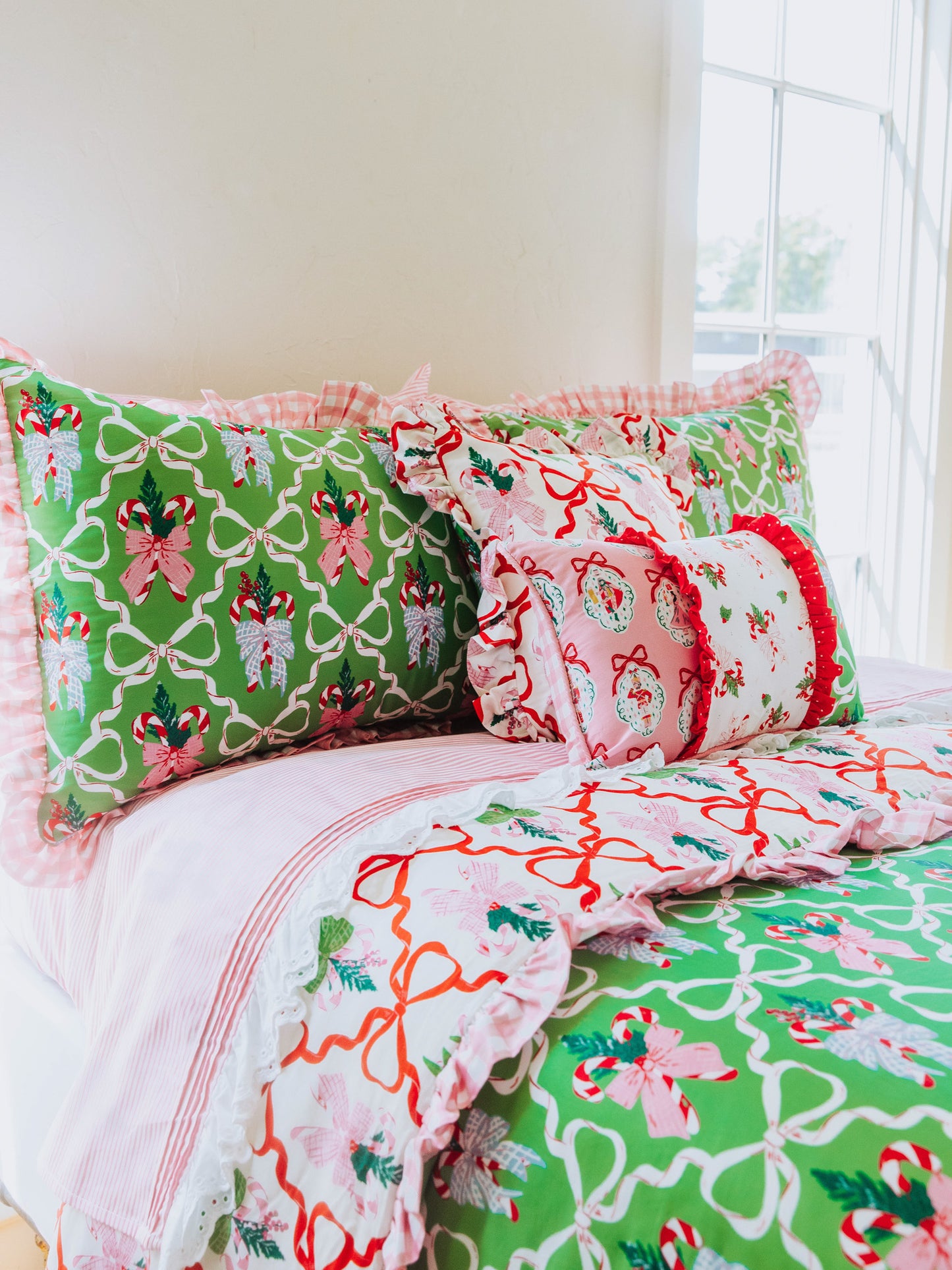 Holiday themed bedding with matching pillows of different sizes. Pink lace sheets. 