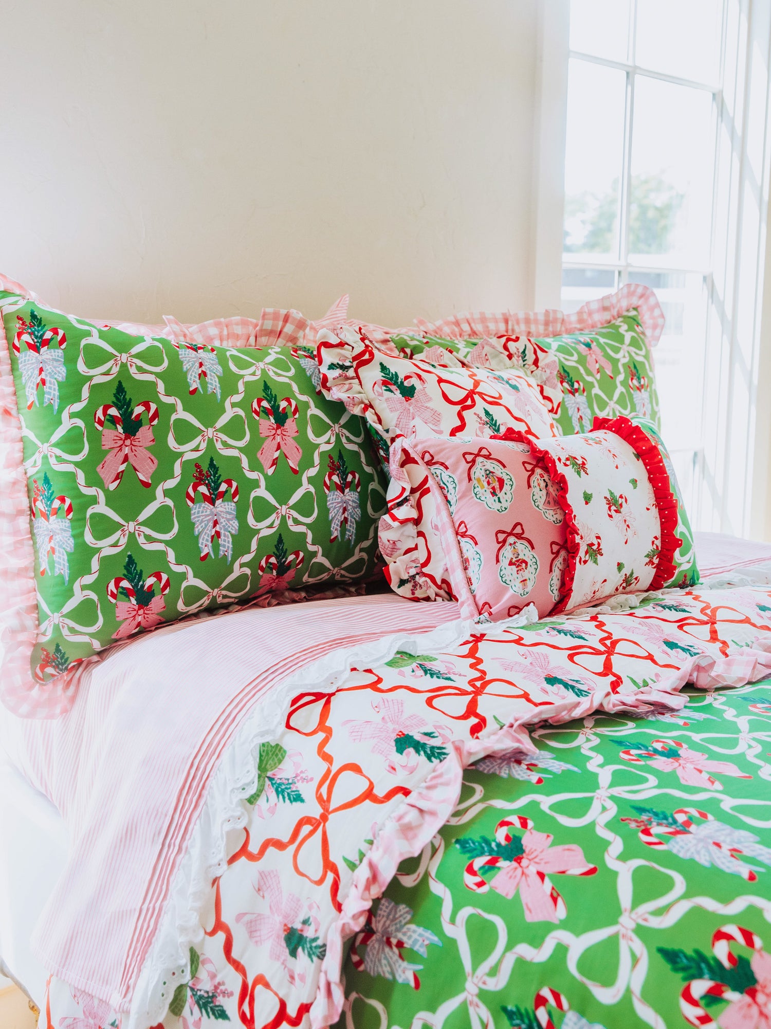 Holiday themed bedding with matching pillows of different sizes. Pink lace sheets. 