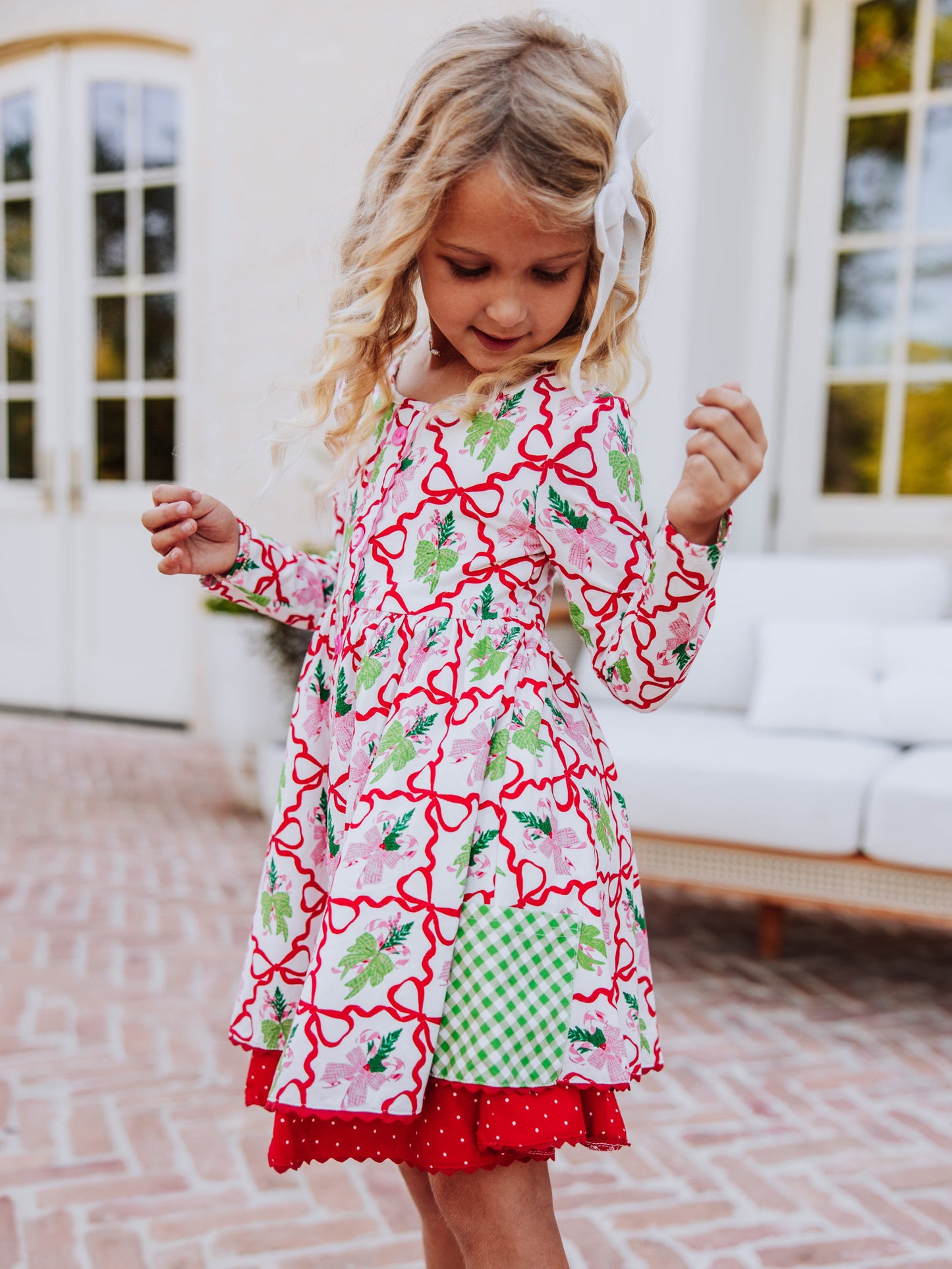 Girl looking down at her holiday themed dress. 