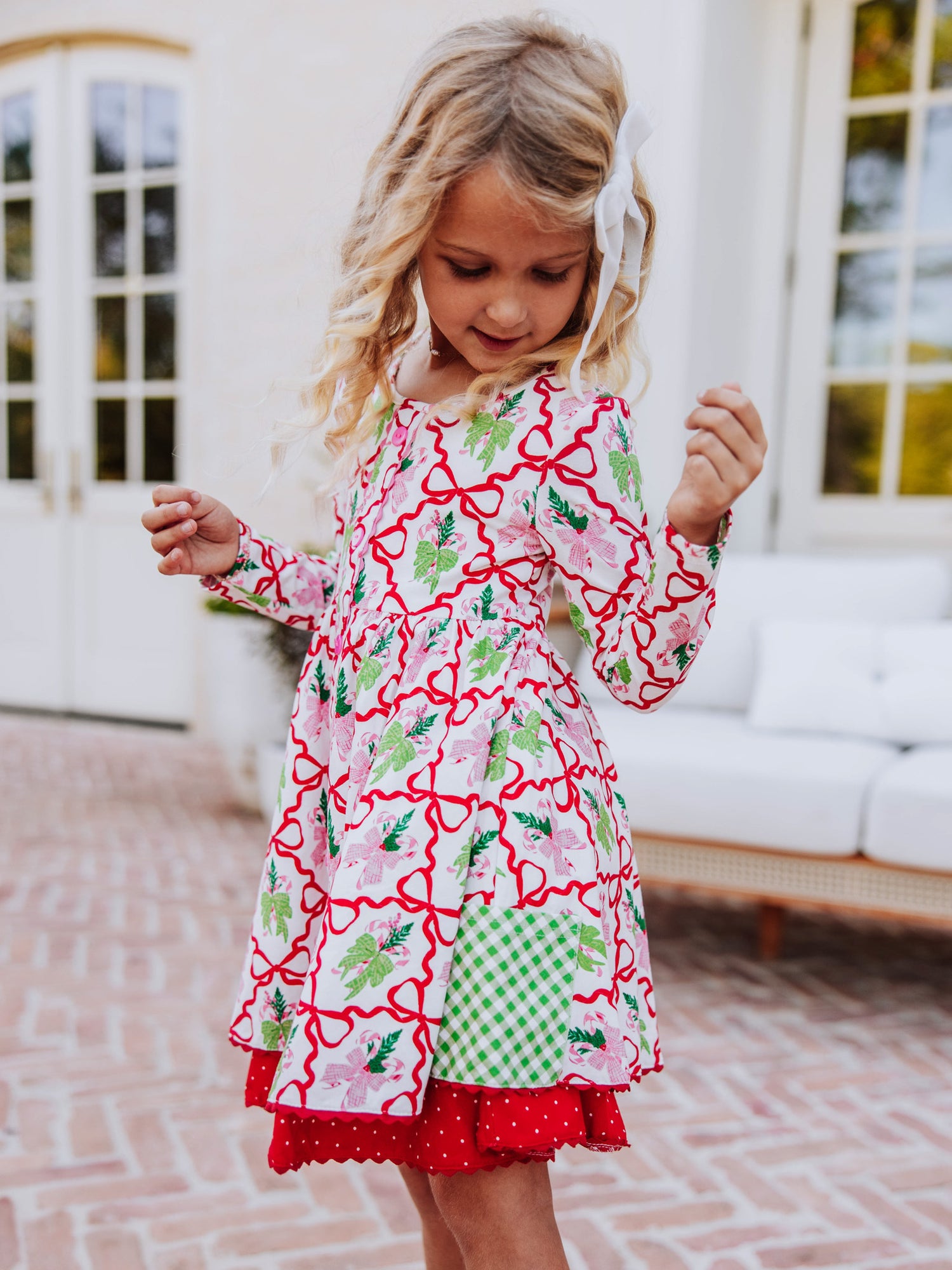 Girl looking down at her holiday themed dress. 