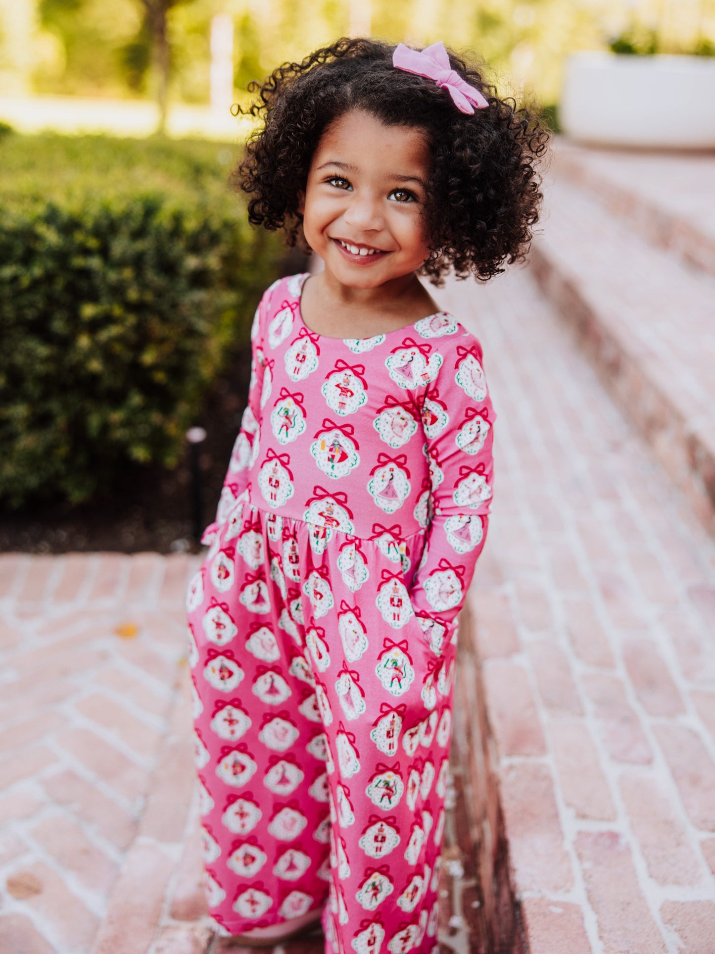 Girl wearing a pink nutcracker printed leggy romper.