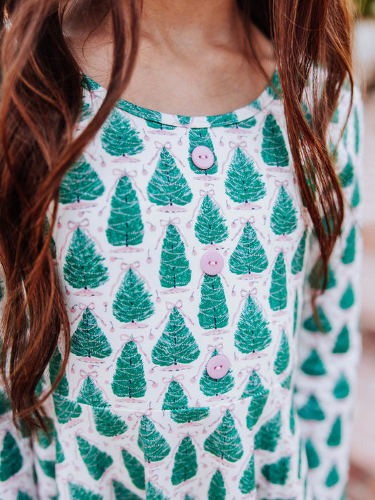 Up close picture of accent buttons on bodice of tree dress with bows on top. 
