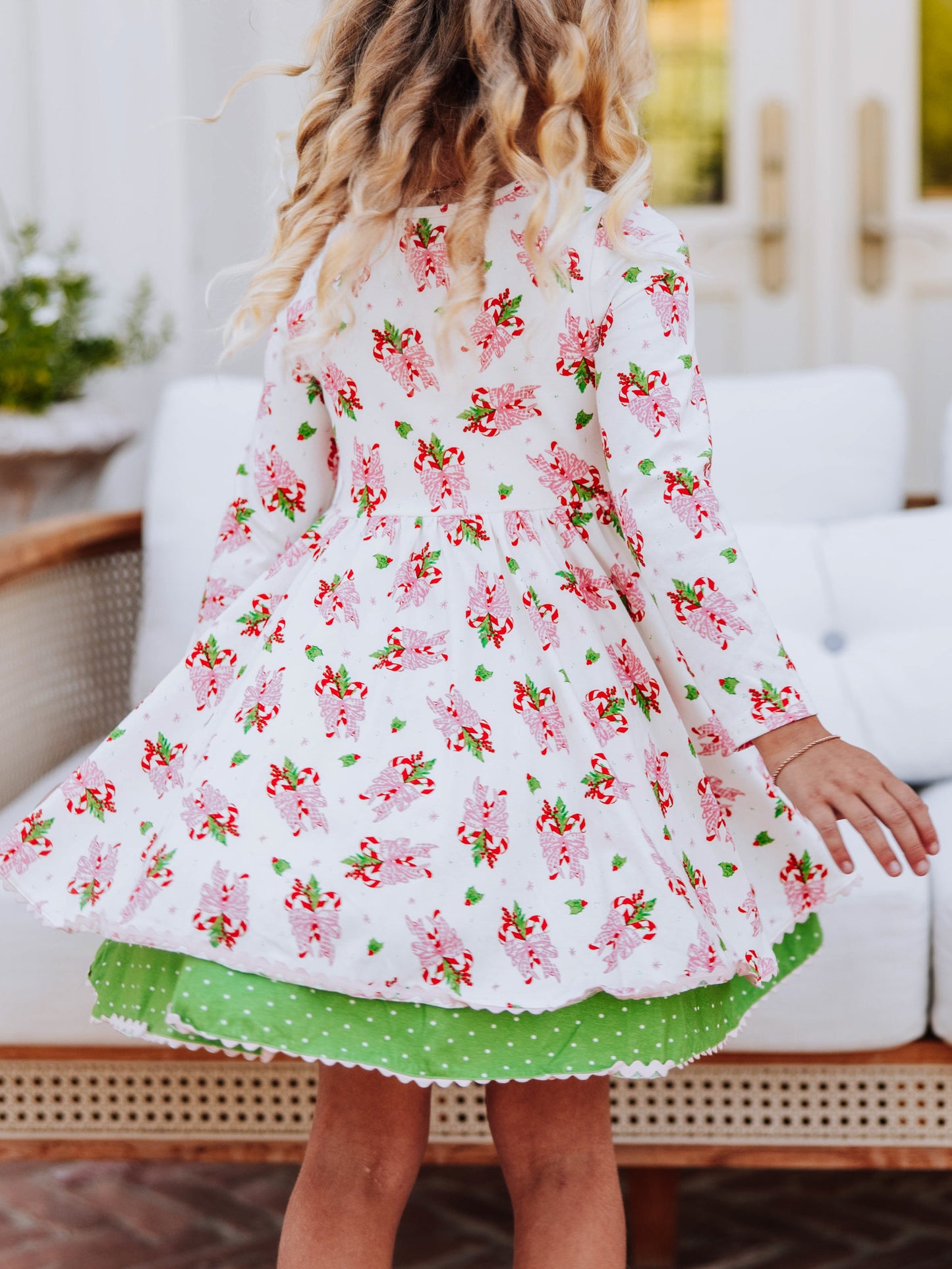 Girl twirling in her holiday printed dress. 