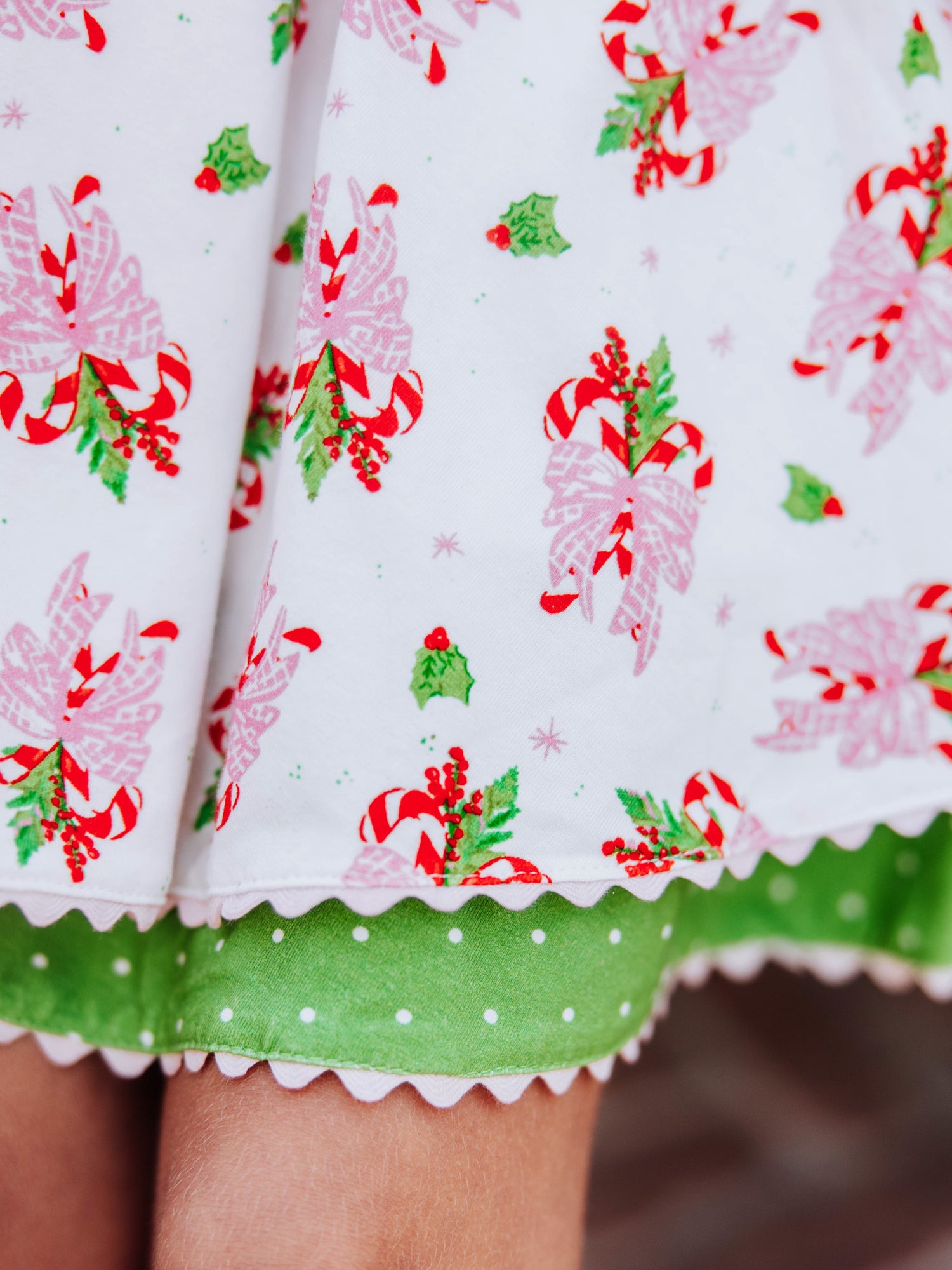 Up close shot of the ric rac trim at bottom of holiday printed dress. 