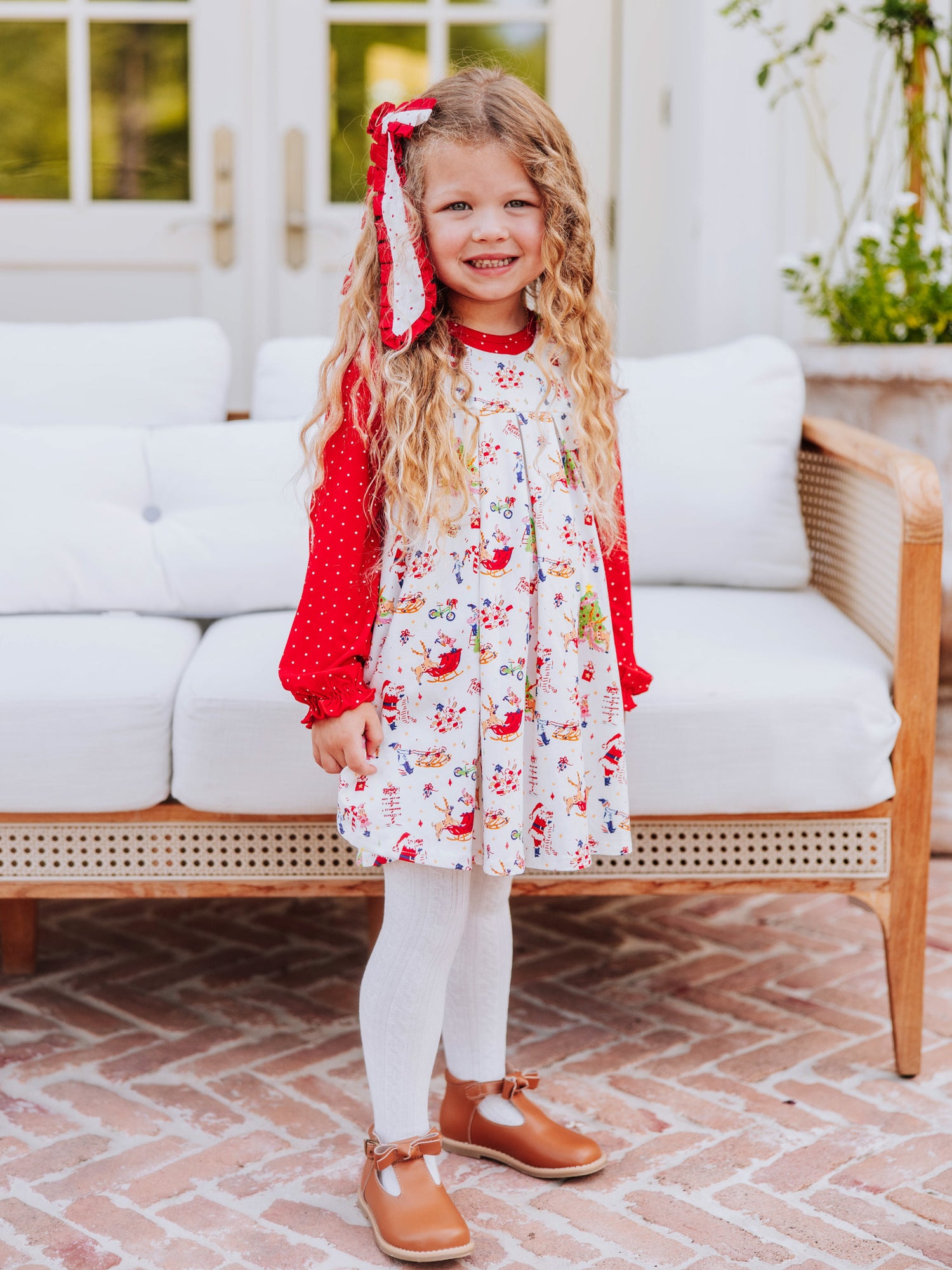 Girl wearing a holiday themed retro jumper with white tights and brown buckle shoes. 