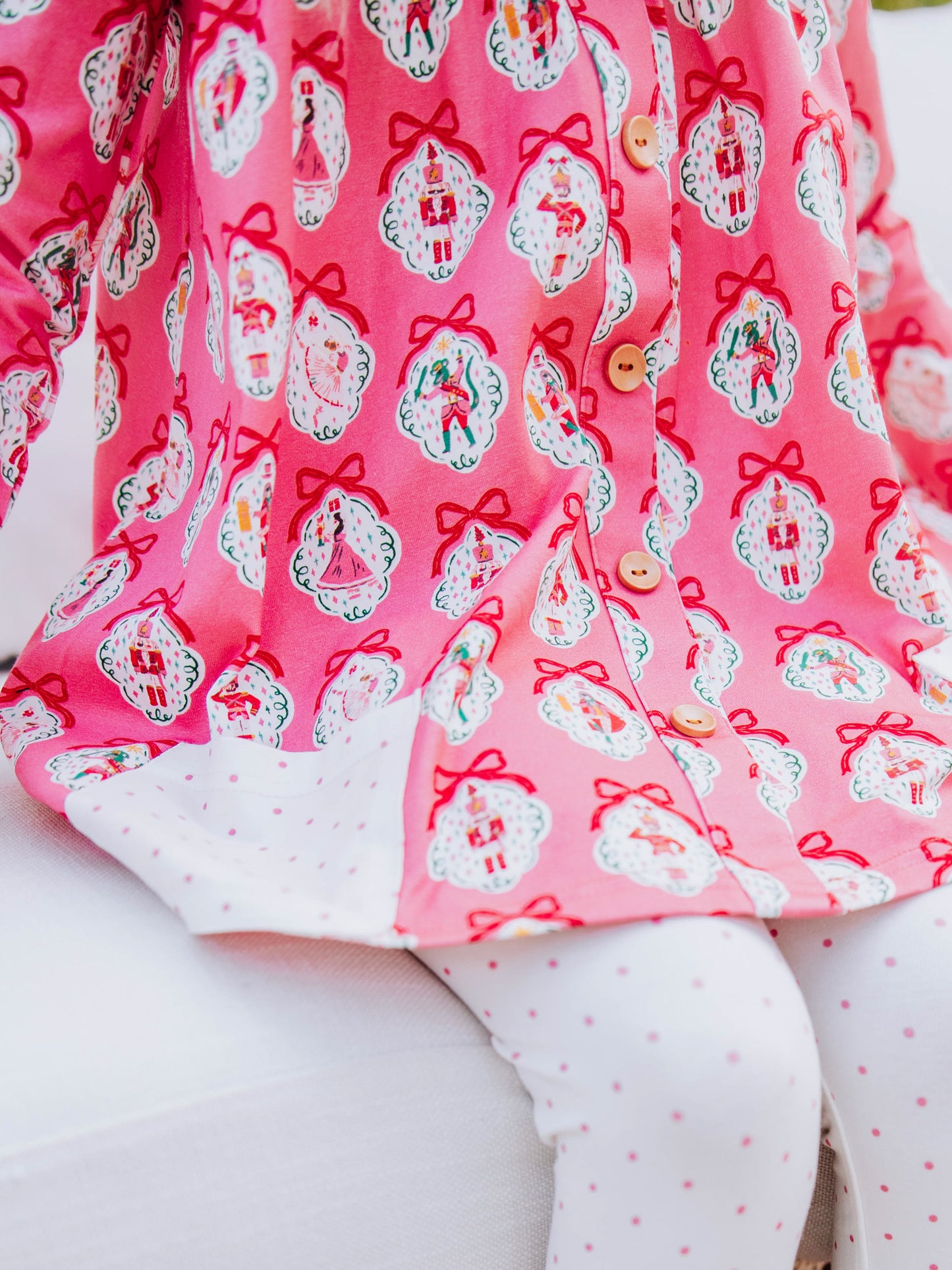 up close picture of holiday themed top and white leggings with pink polka dots