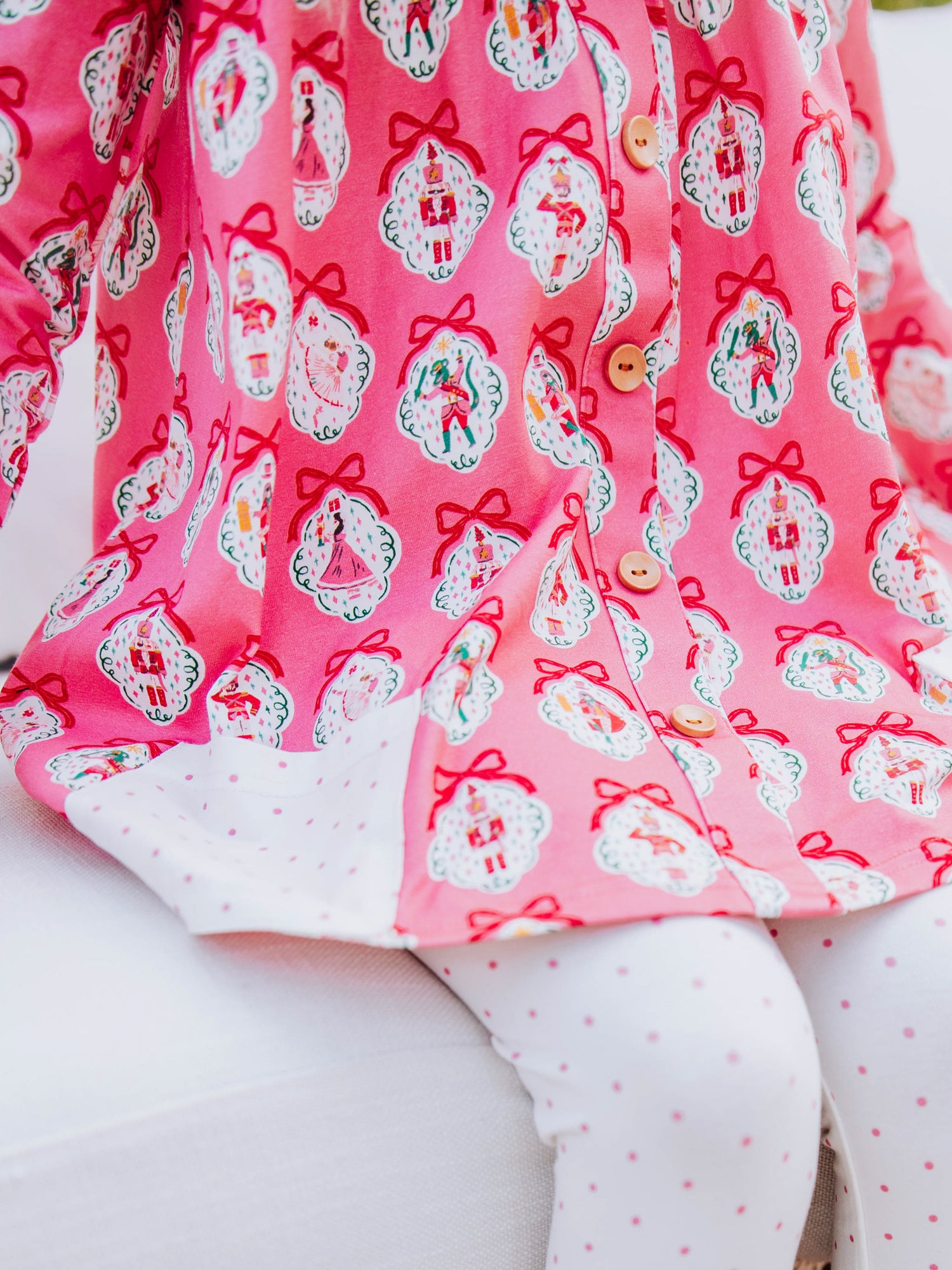 up close picture of holiday themed top and white leggings with pink polka dots