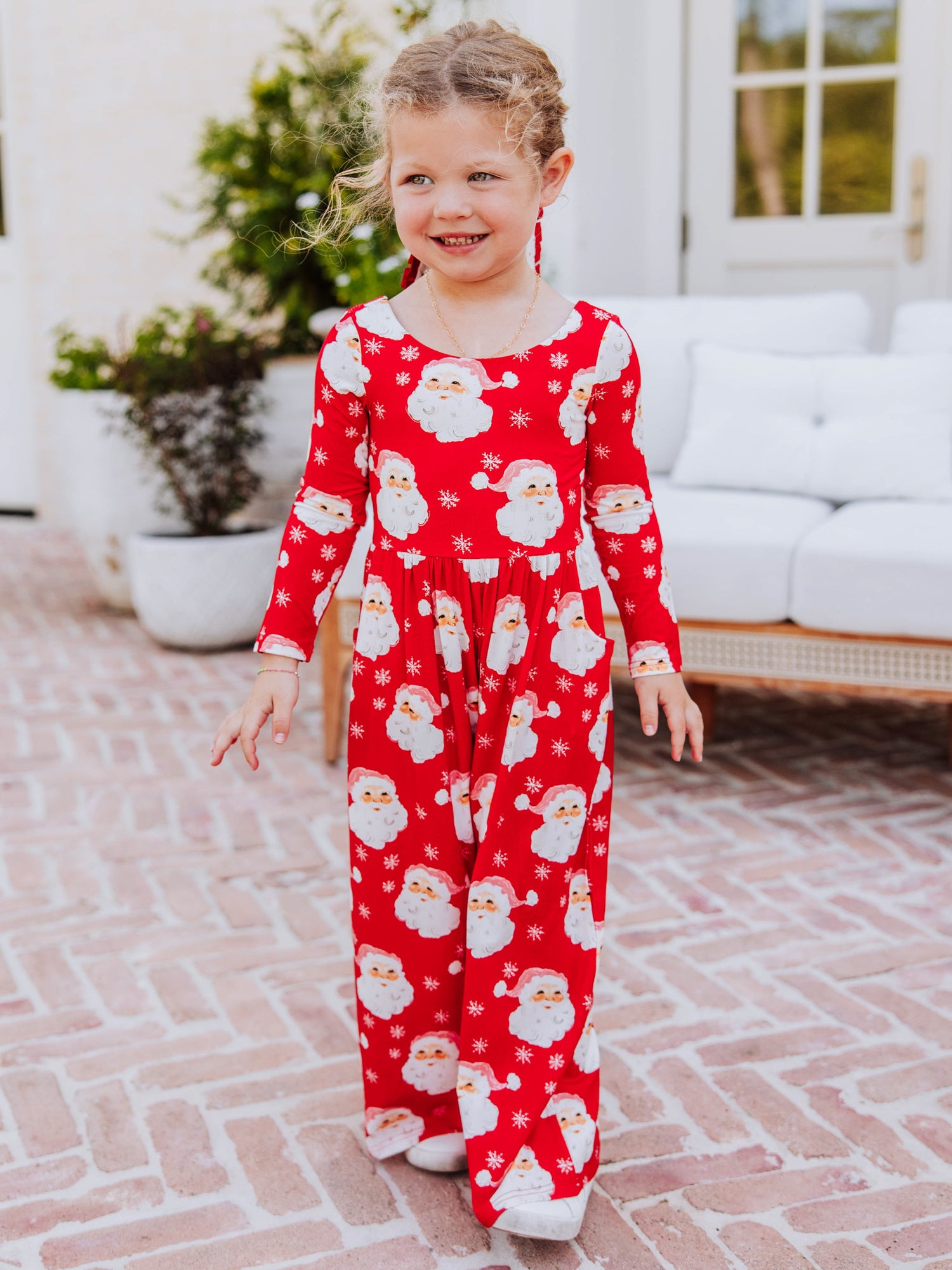Girl wearing a jolly santa leggy romper 