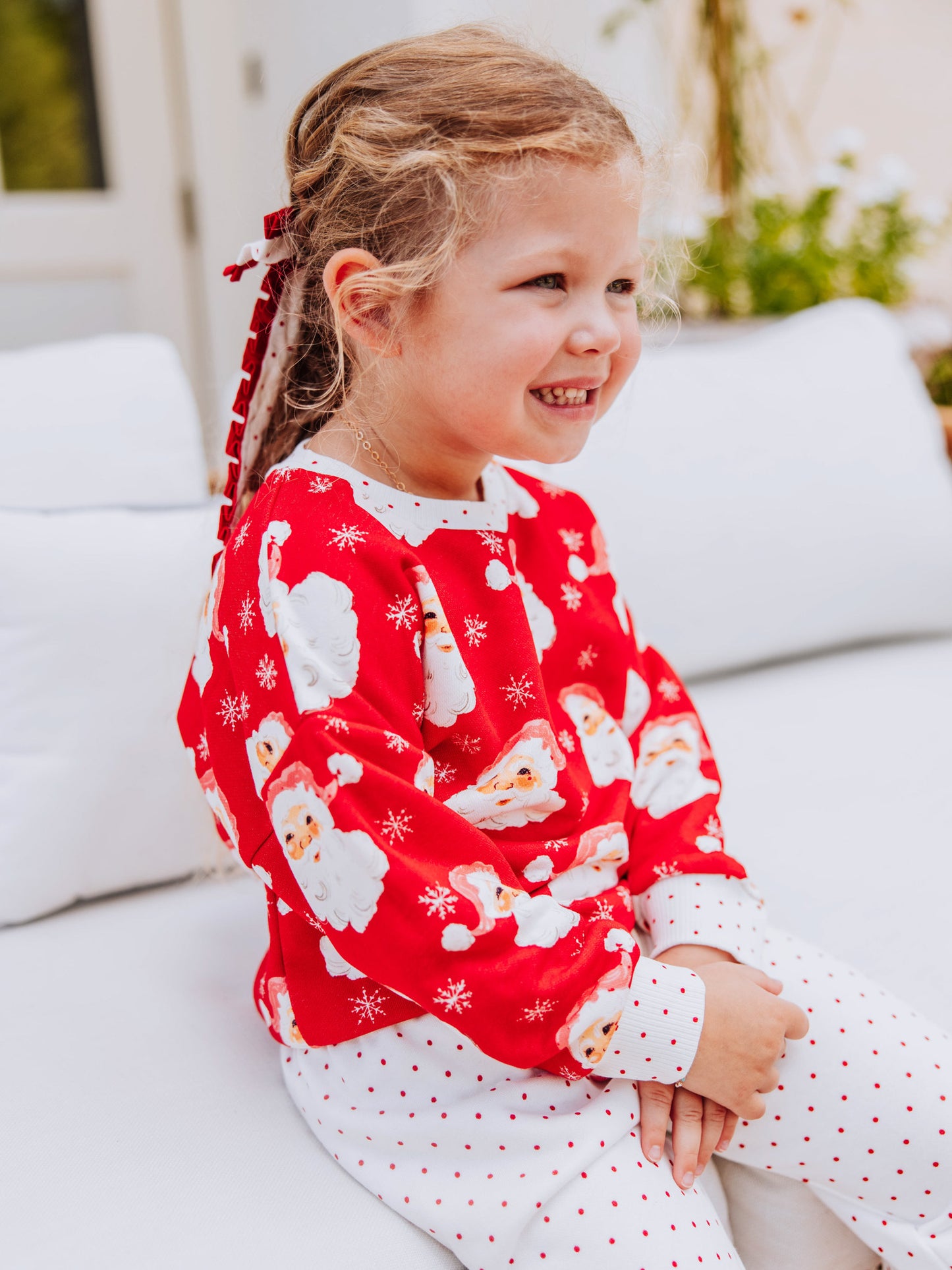 Girl outside wearing a jolly santa sweat set. 