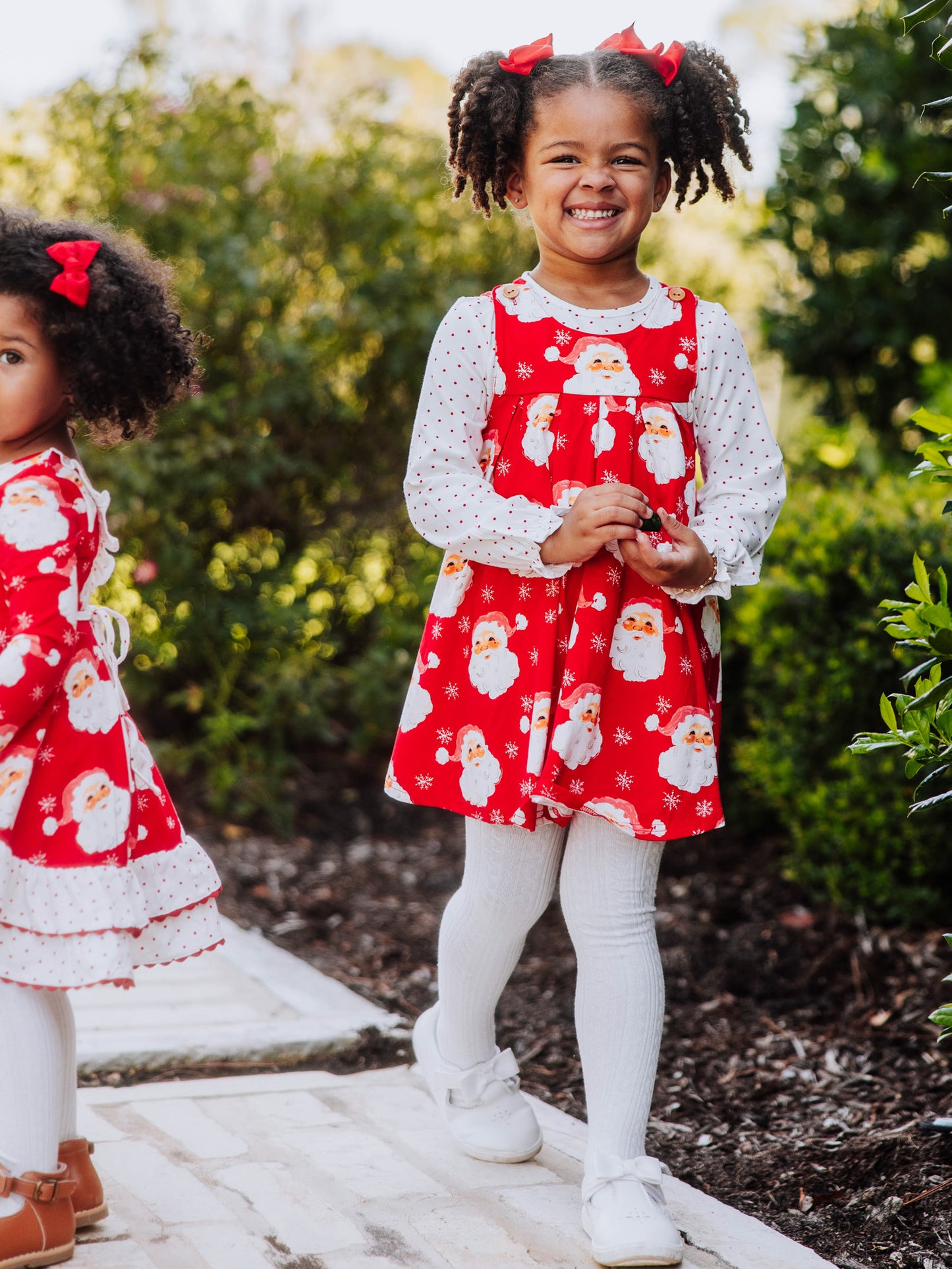 Girls both wearing matching holiday themed attire. 