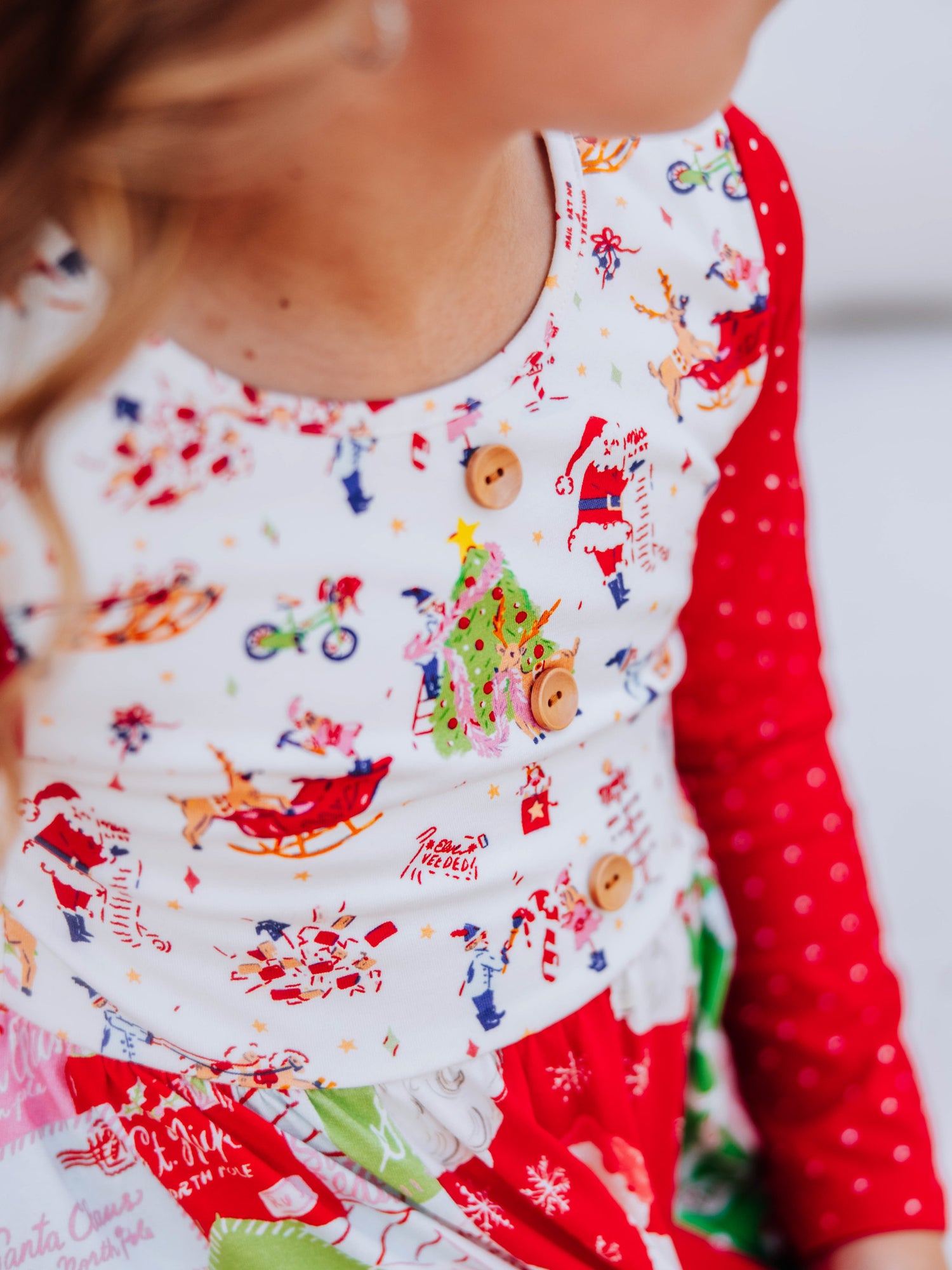 Up close shot of accent buttons on bodice of holiday printed dress. 