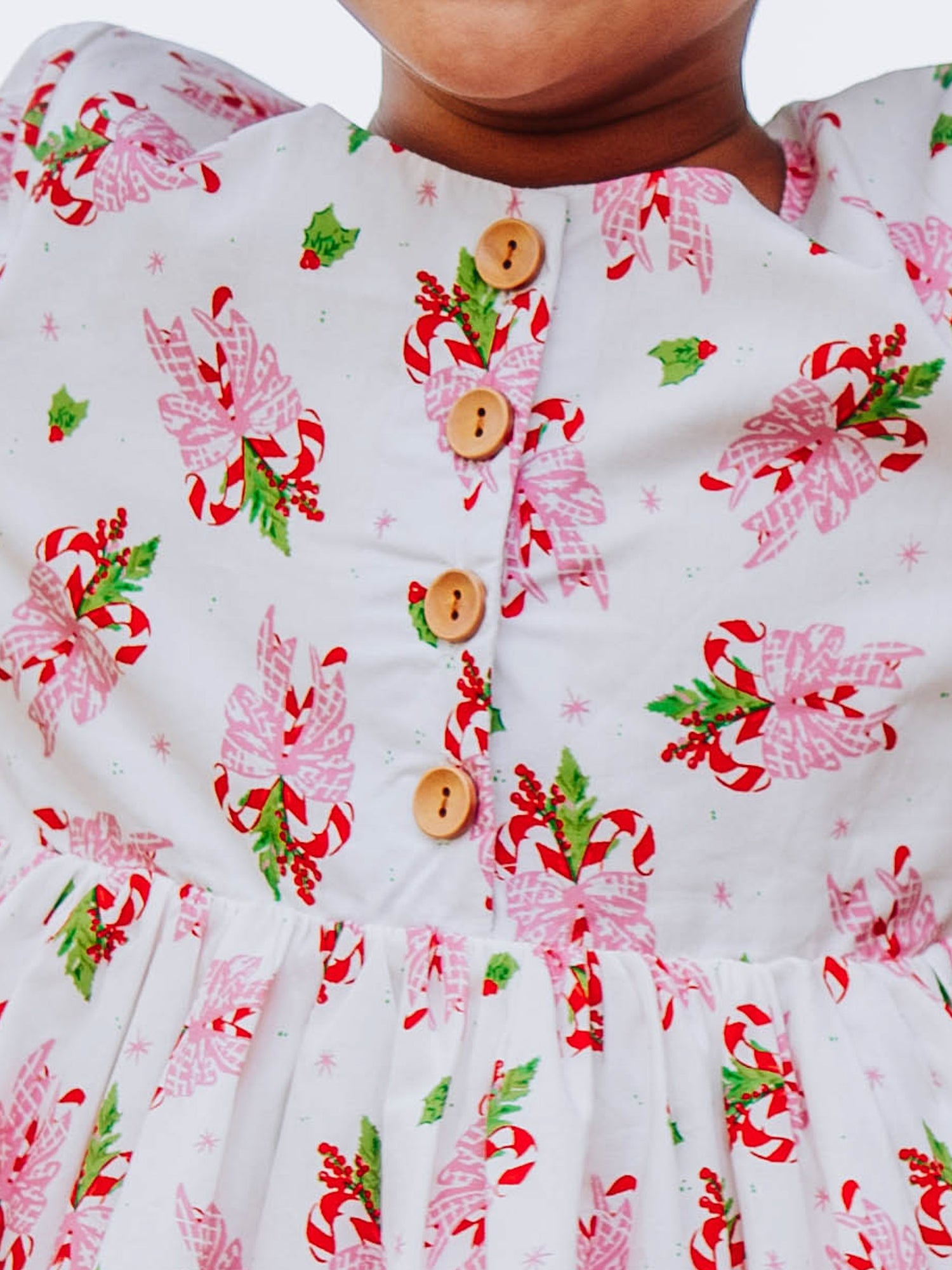 Up close shot of functional buttons on bodice of holiday themed dress. 