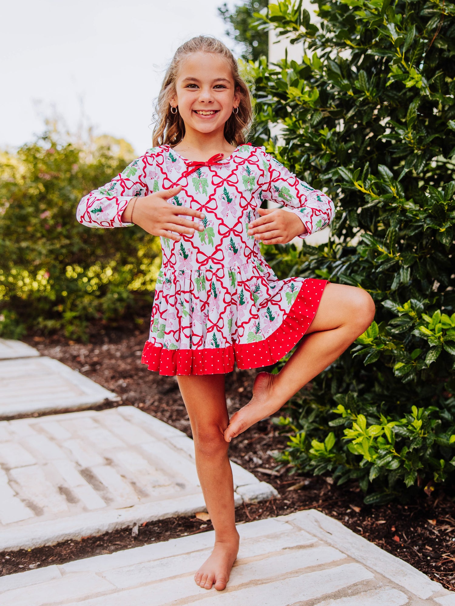 Girl wearing a holiday themed leotard posing in a ballet move. 