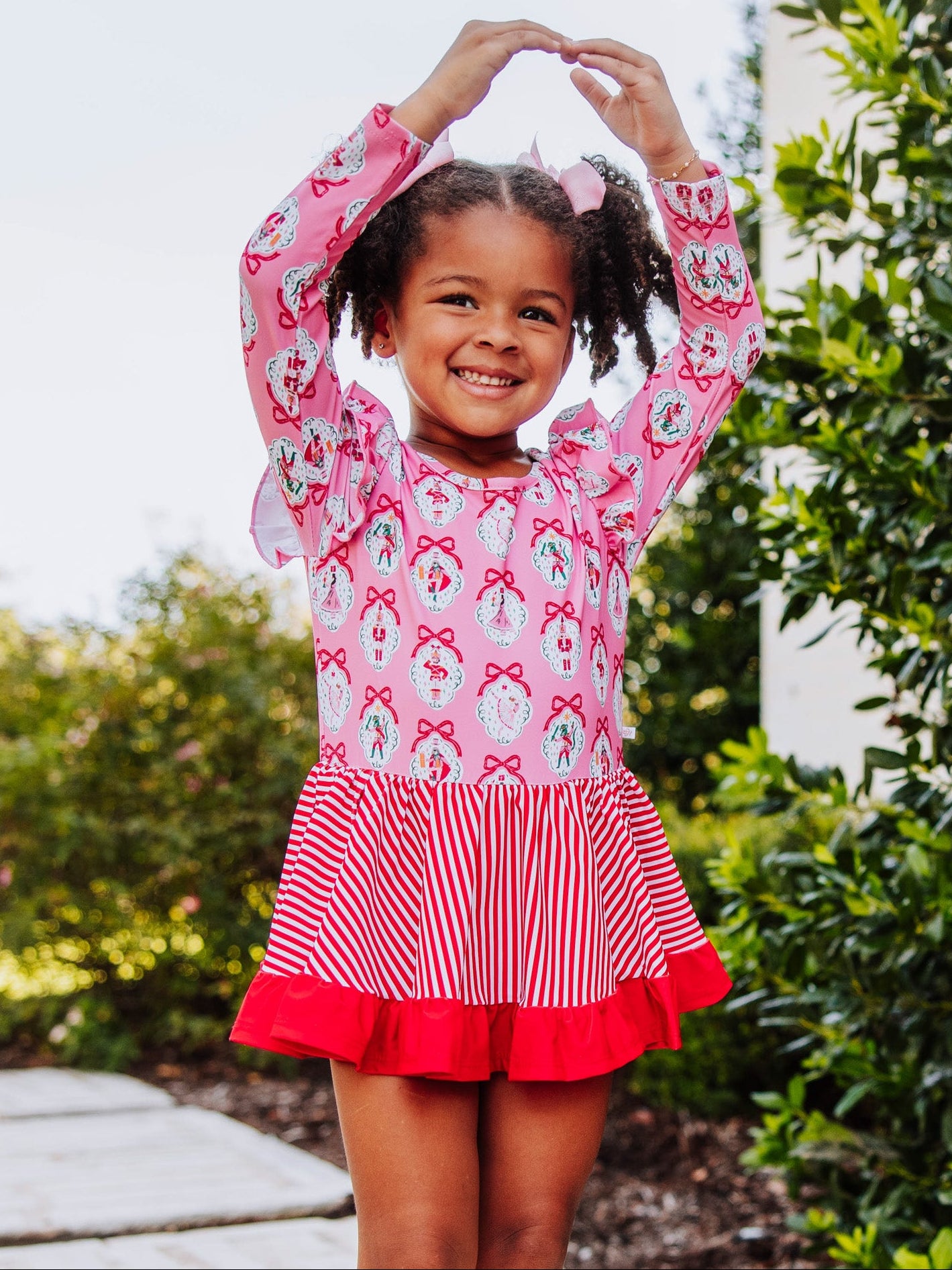 Girl wearing a holiday themed leotard posing in a ballet move. 