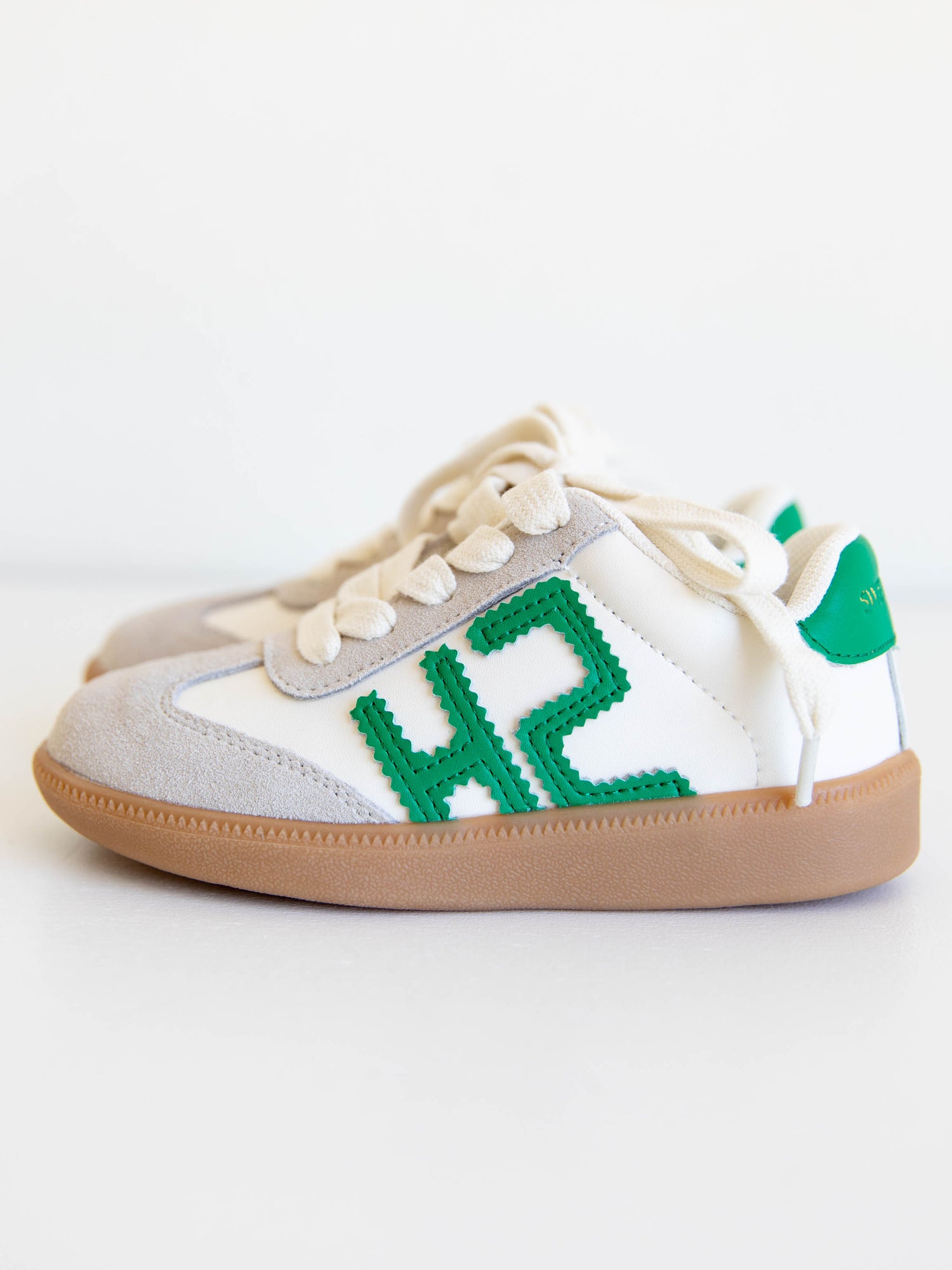 Fresh, fun, and full of SweetHoney style — our Signature Sneakers in green and white are the perfect mix of comfort and charm! Featuring our bold “SH” SweetHoney logo, soft suede accents, and durable gum soles, these boutique kids’ sneakers are designed for everyday adventures. Whether paired with twirl dresses or playtime outfits, they’re the ultimate blend of fashion and function for little trendsetters on the go.