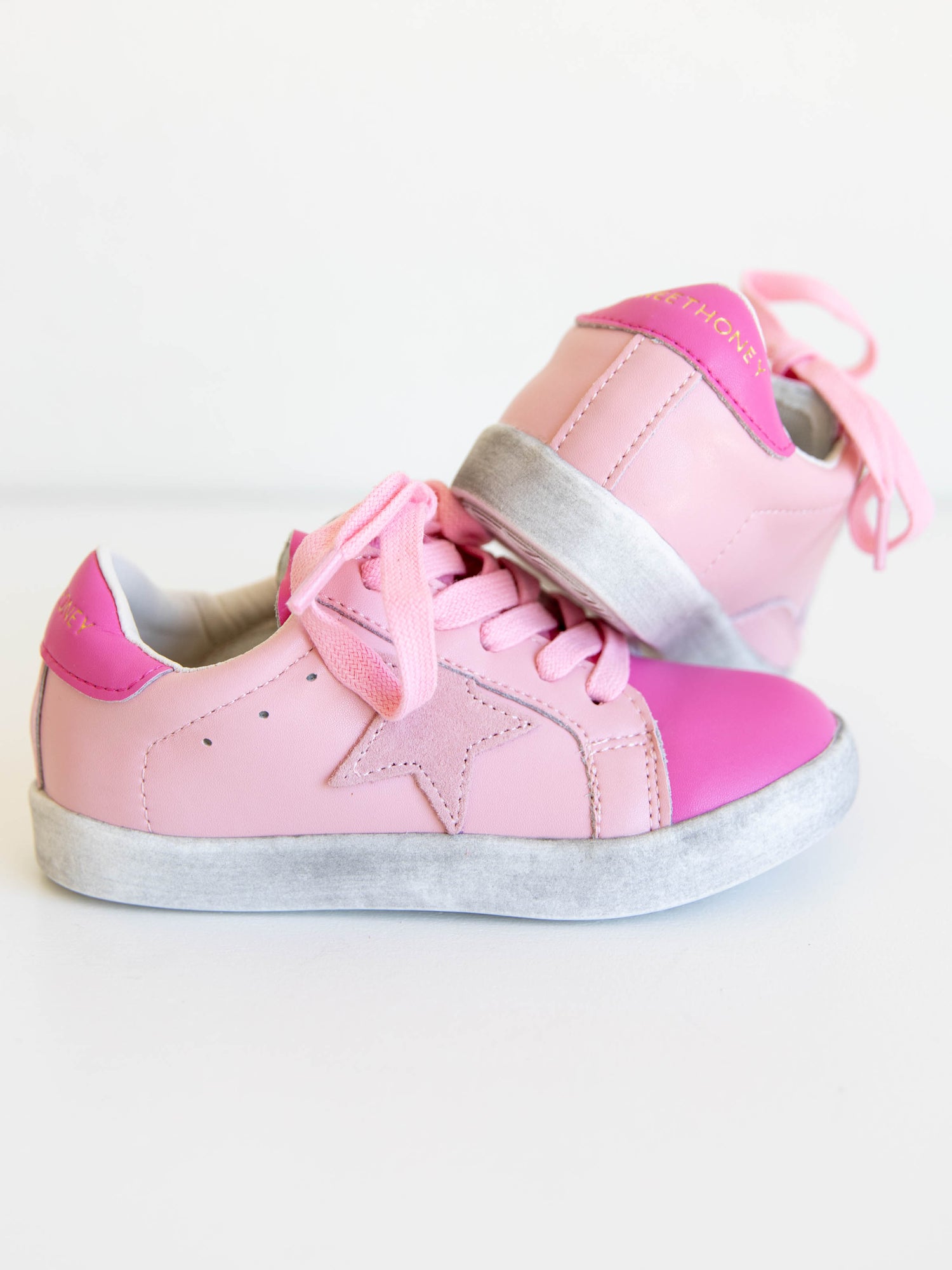 Step into sparkle and style with our SweetHoney Star Sneakers in pretty shades of pink! These boutique kids’ sneakers feature a glittery star detail, soft suede accents, and comfy rubber soles — perfect for playdates, school days, or twirling through the weekend. Designed for both comfort and cuteness, these girls pink sneakers add a touch of magic to every outfit while keeping little feet supported all day long.