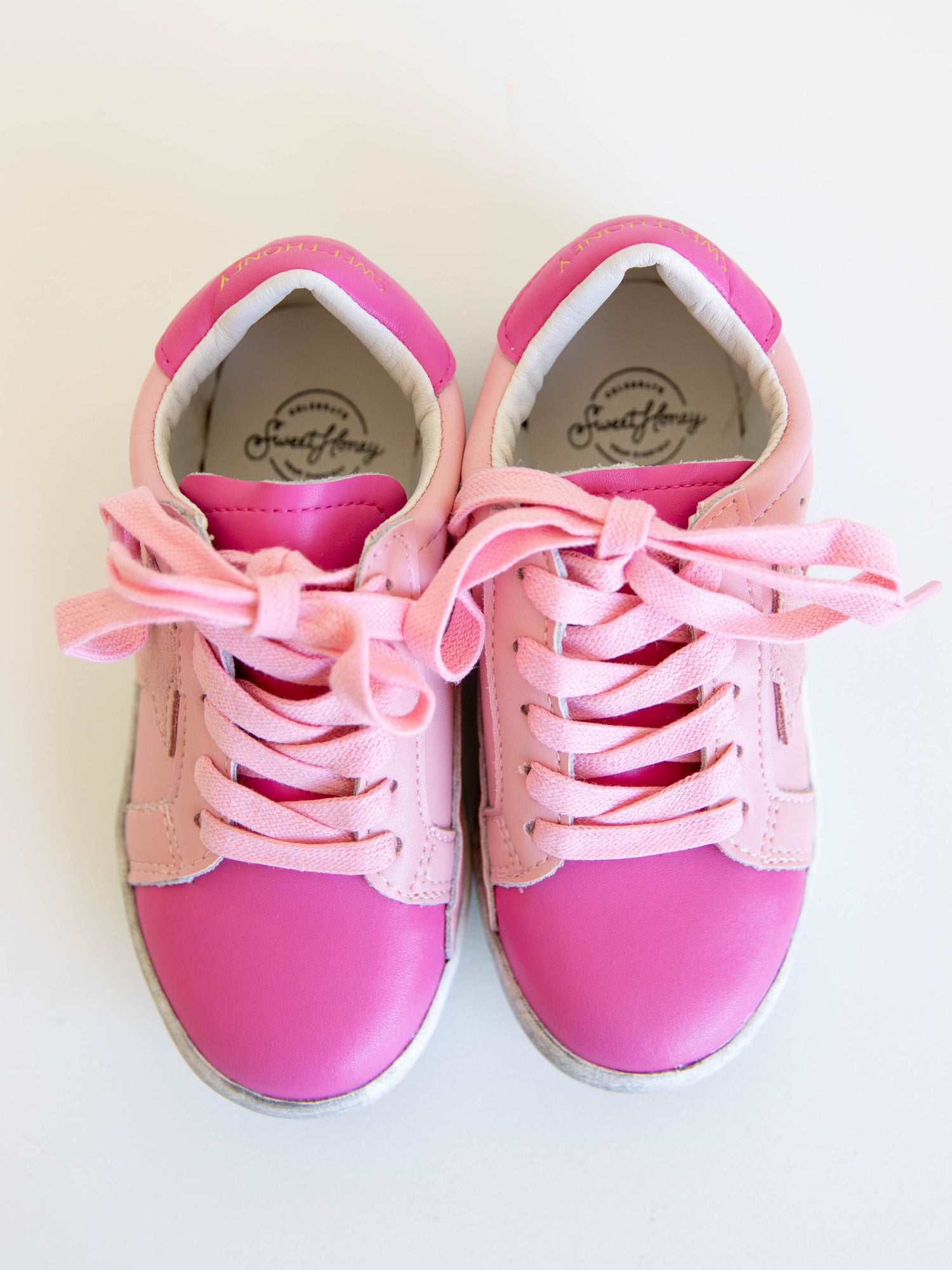 Step into sparkle and style with our SweetHoney Star Sneakers in pretty shades of pink! These boutique kids’ sneakers feature a glittery star detail, soft suede accents, and comfy rubber soles — perfect for playdates, school days, or twirling through the weekend. Designed for both comfort and cuteness, these girls pink sneakers add a touch of magic to every outfit while keeping little feet supported all day long.