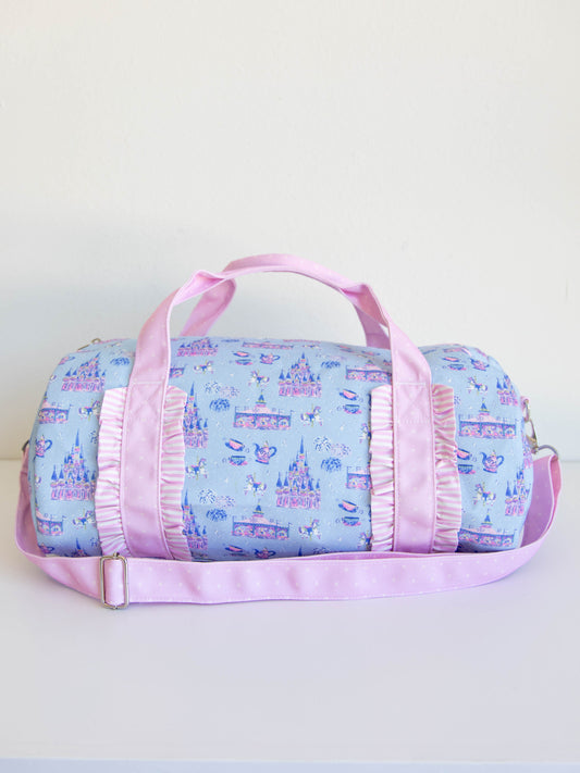Pack the fun for every adventure with our Most Magical Duffle Bag! Featuring a playful allover print inspired by enchanting castles, whimsical teacups, and sparkling fireworks, this kids travel bag is perfect for sleepovers, vacations, and dance days. Made from durable, easy-to-clean fabric with sturdy handles and an adjustable shoulder strap, it’s designed to hold all your little one’s essentials in magical style.