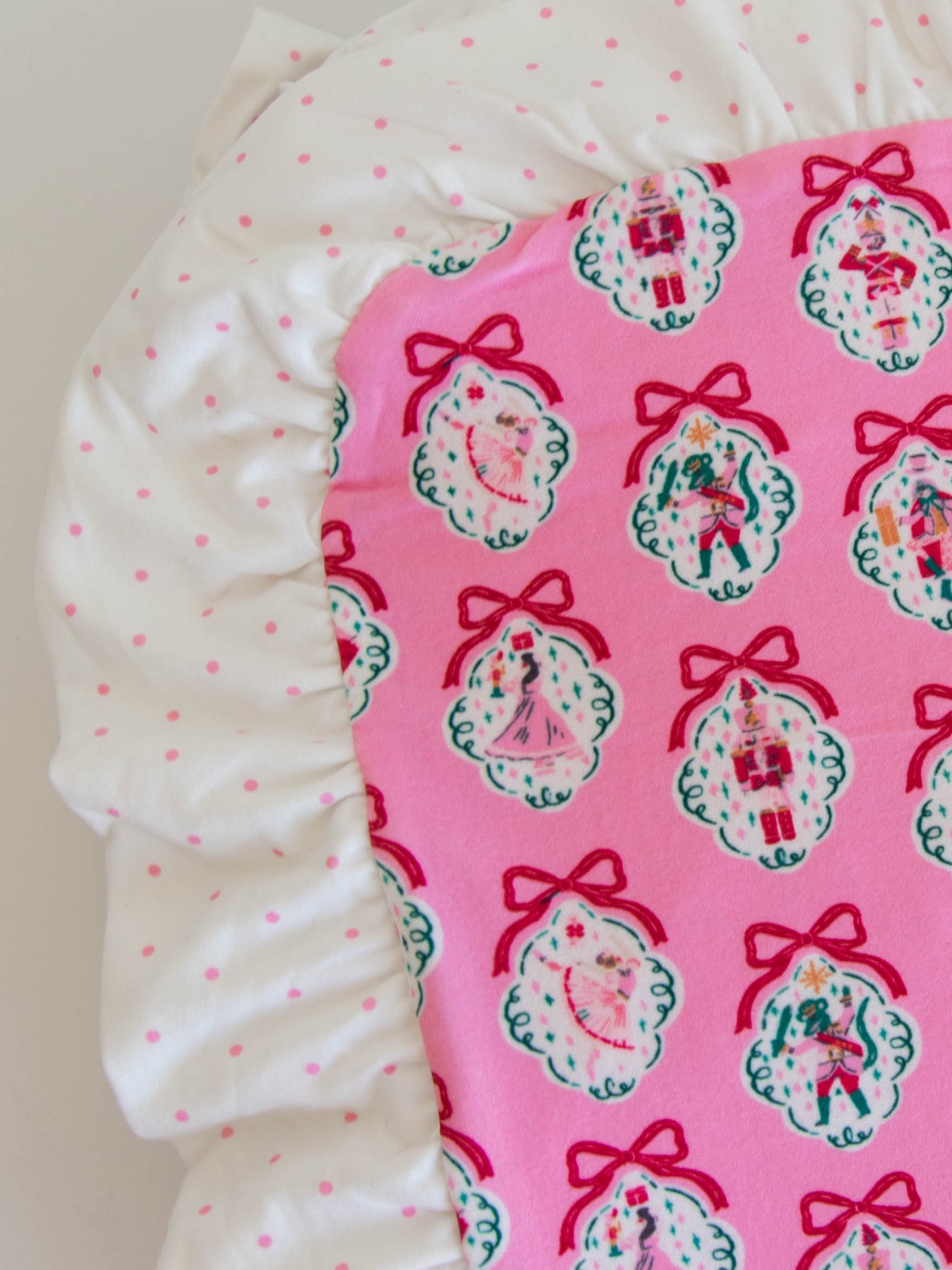 Up close photo of ruffles on pink nutcracker blanket.