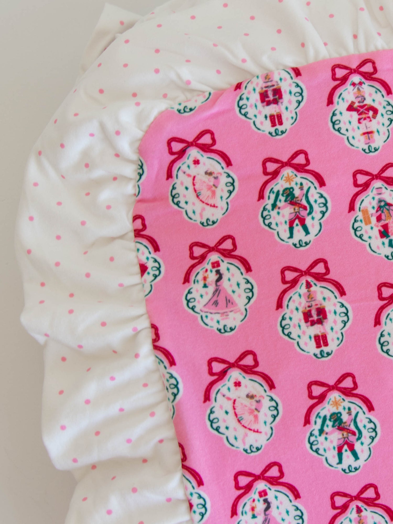 Up close photo of ruffles on pink nutcracker blanket.