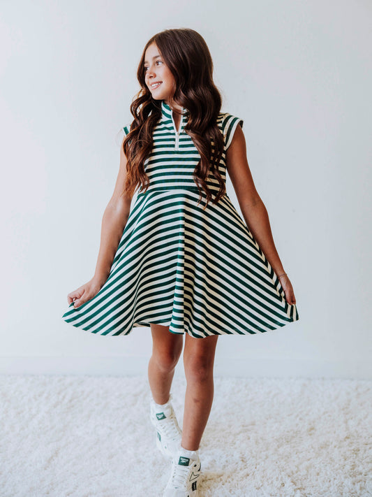 Model wearing a green and ivory striped dress. Dress has a zipper closure at chest. 