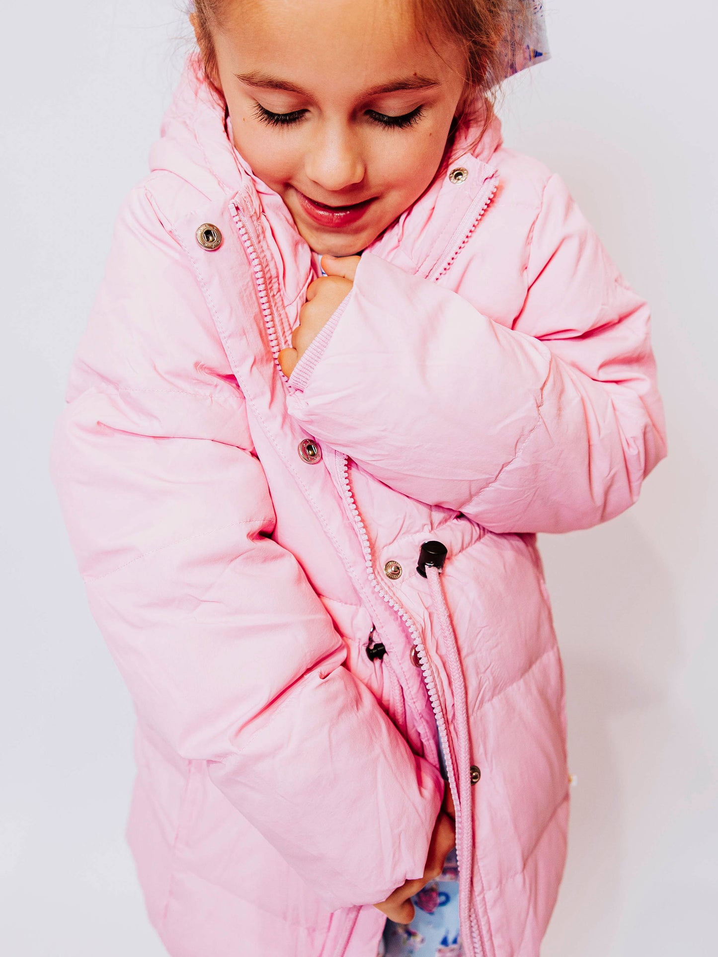 Keep her cozy and cute all season long in our Pink Puffer Jacket — the perfect blend of warmth and style! This soft, quilted jacket features a full zipper closure with a button placket, ensuring extra protection from chilly winds. Hidden front pockets keep little hands warm (or treasures tucked away), while the adjustable waist toggle allows for the perfect, comfortable fit. Designed in a beautiful blush pink hue, this girls’ puffer jacket pairs effortlessly with any winter outfit for a look that's fun!