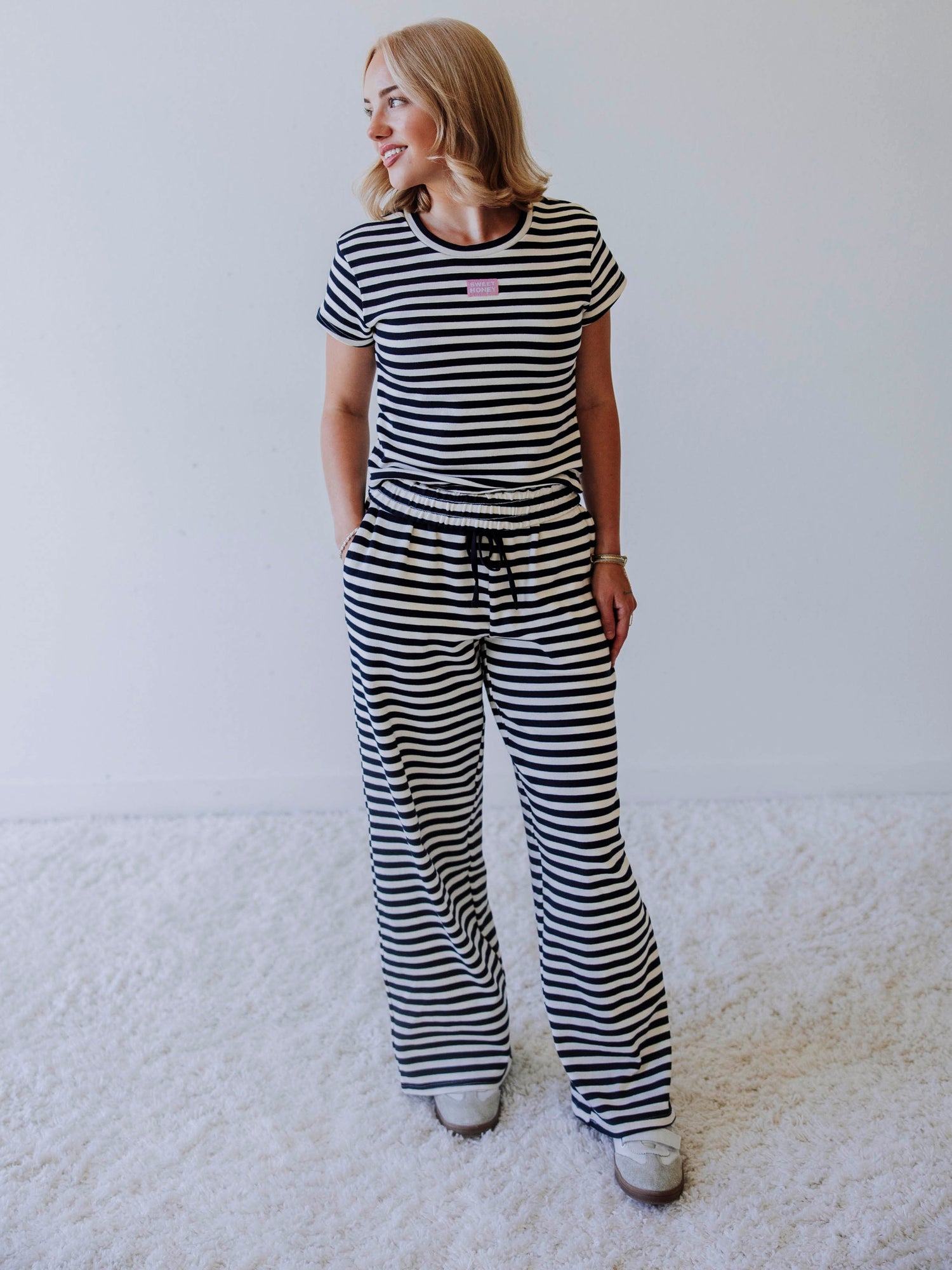 Model is wearing a two piece, navy and ivory pant set. Top has a stitched Sweethoney tag centered on chest. 