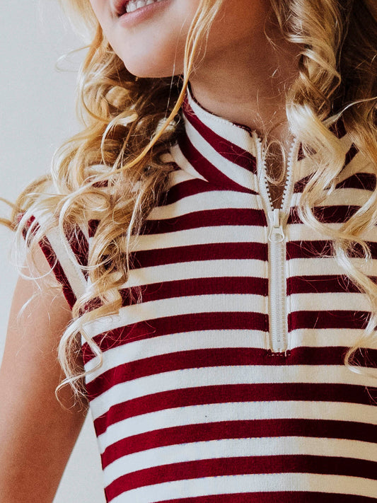 Up close picture of the zipper closure on a crimson and ivory striped dress. 