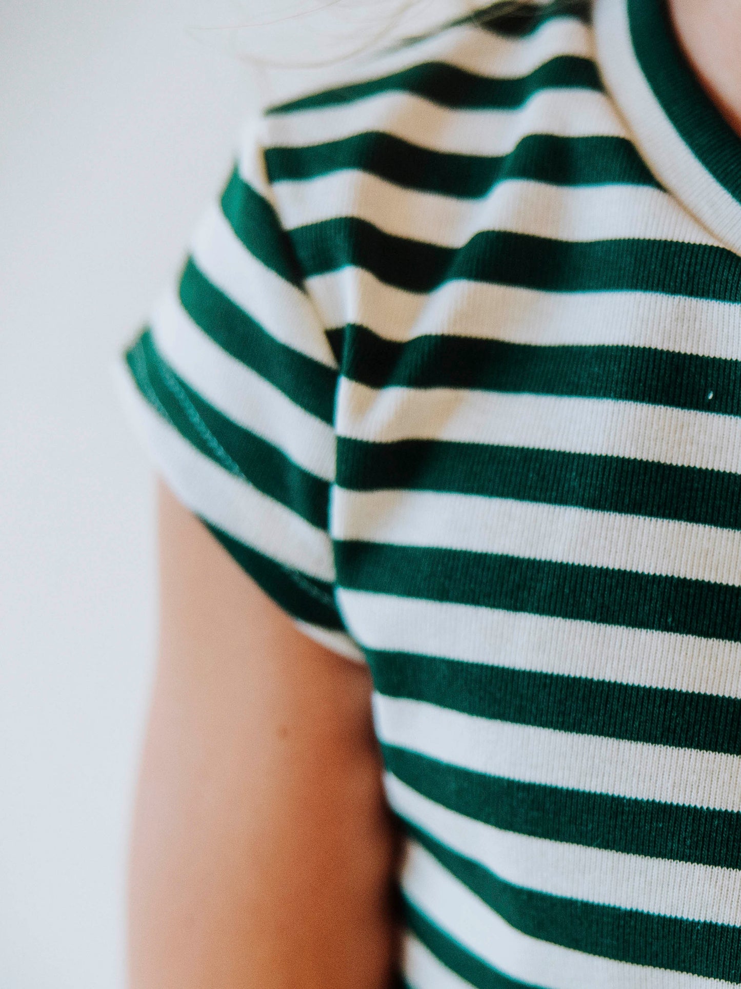 Up close picture of the cap sleeve on the ivory and green striped shirt. 