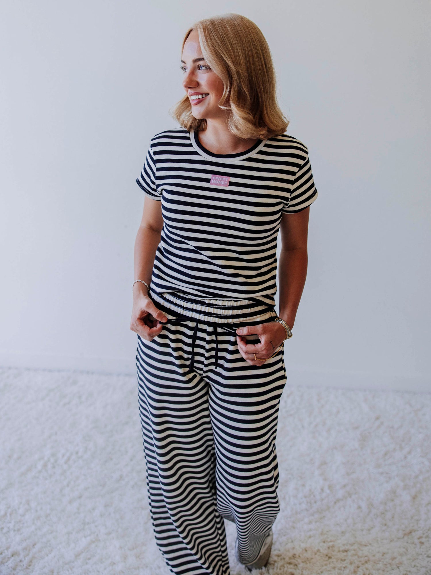 Model is wearing a two piece, navy and ivory pant set. Top has a stitched Sweethoney tag centered on chest. 