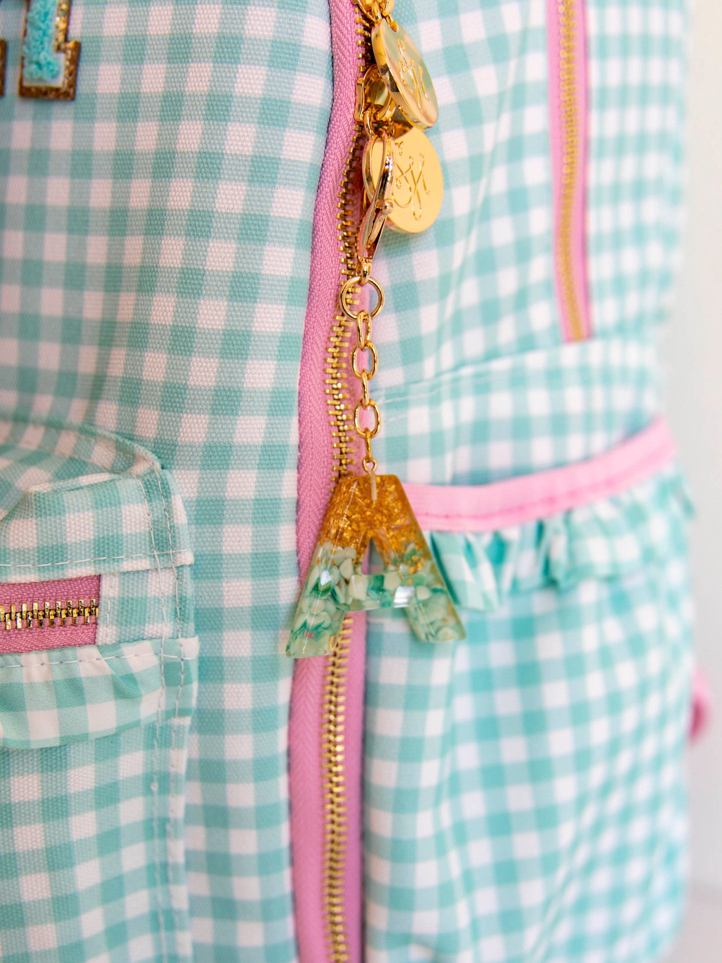 Letter keychain attached to mint green gingham backpack