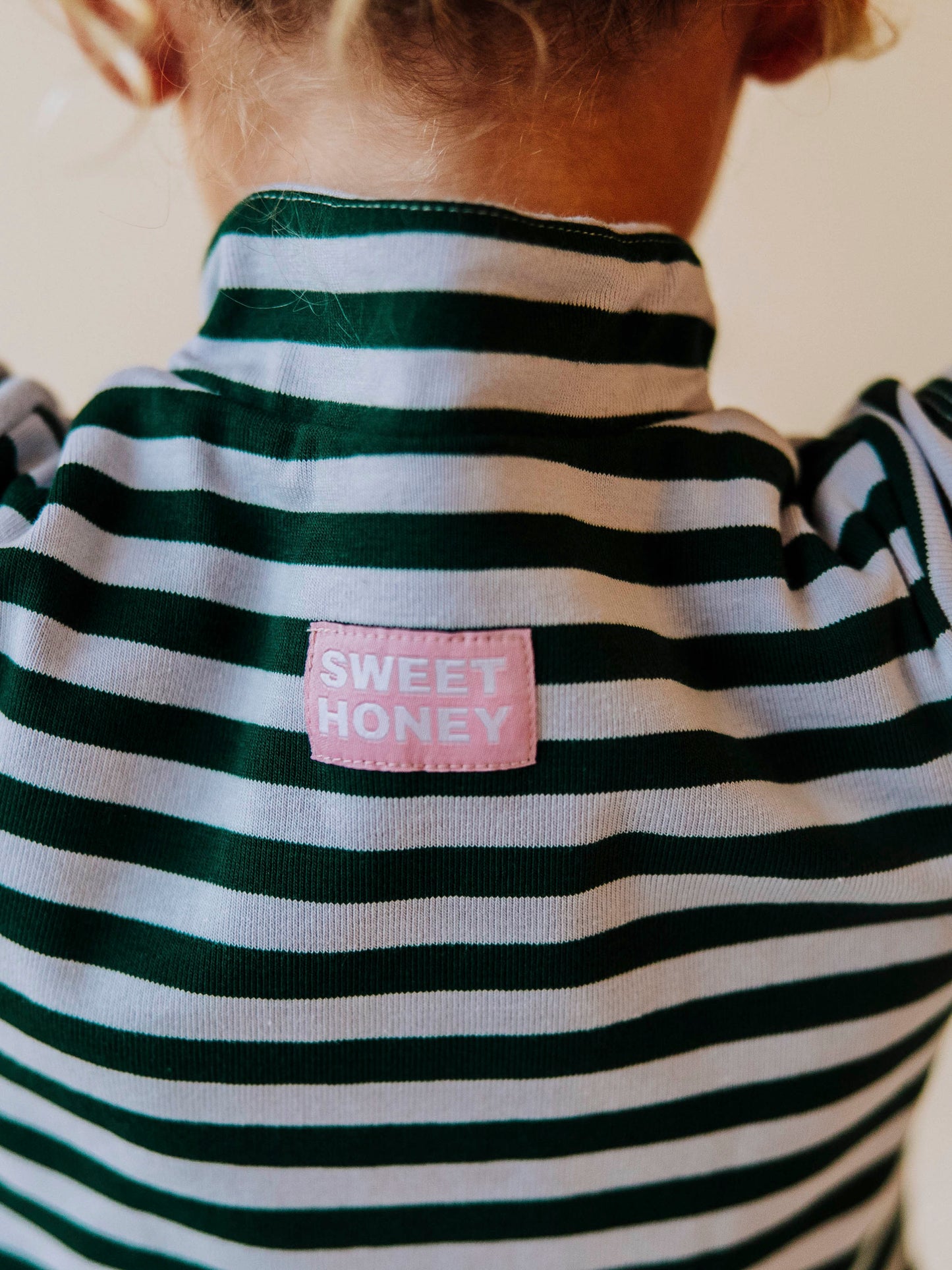 Green and gray colored garment that has a sweethoney logo tag stitched at back. 
