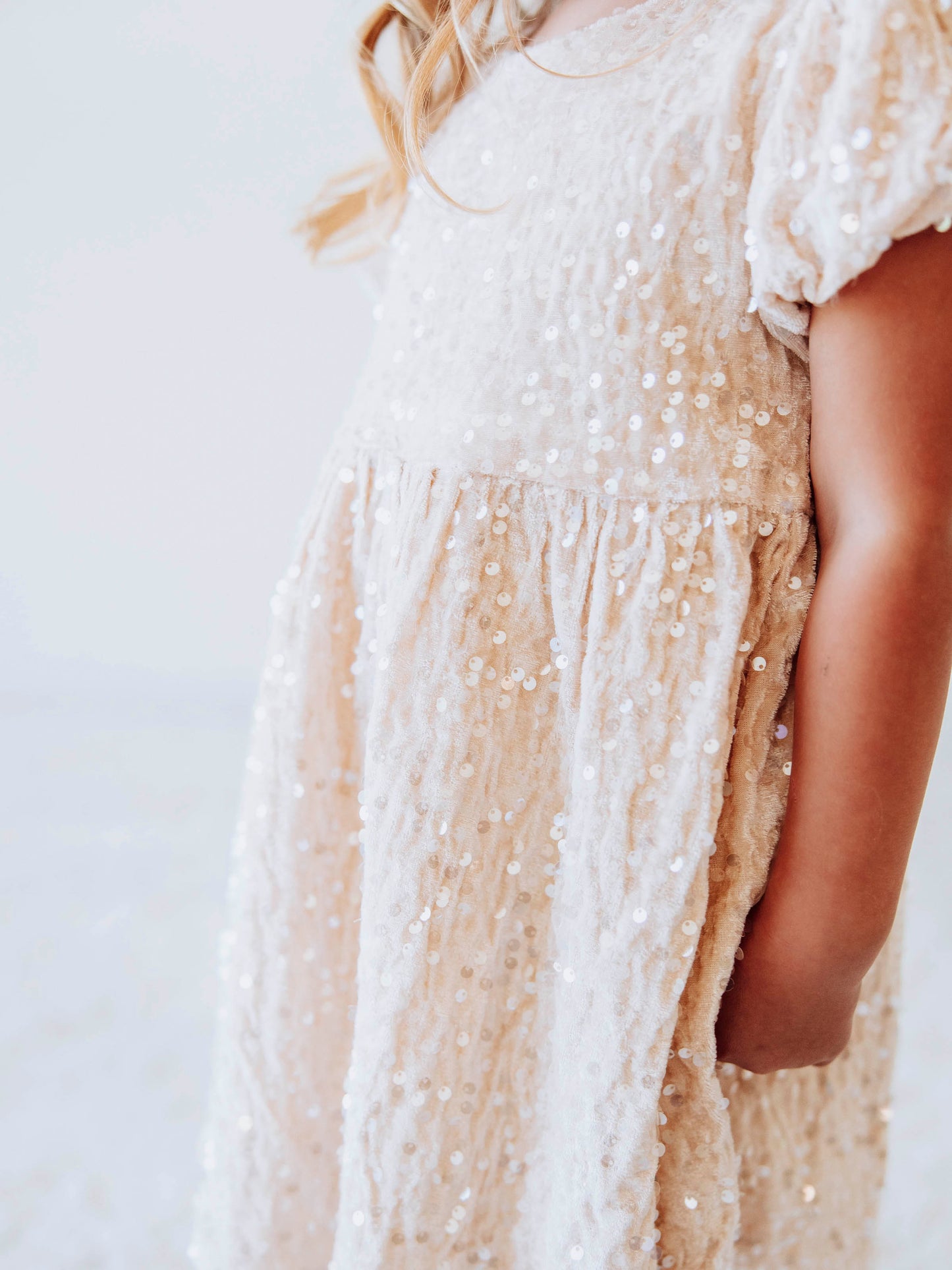 Make every moment shine in our Girls’ Sequin Sparkle Dress, designed for holiday parties, special occasions, and picture-perfect moments. Crafted from 100% polyester, this dress features a soft velvet-like texture that’s gentle on the skin and a smooth interior lining for all-day comfort. The fabric is covered in shimmering transparent sequins that catch the light beautifully, creating a dazzling effect with every twirl.