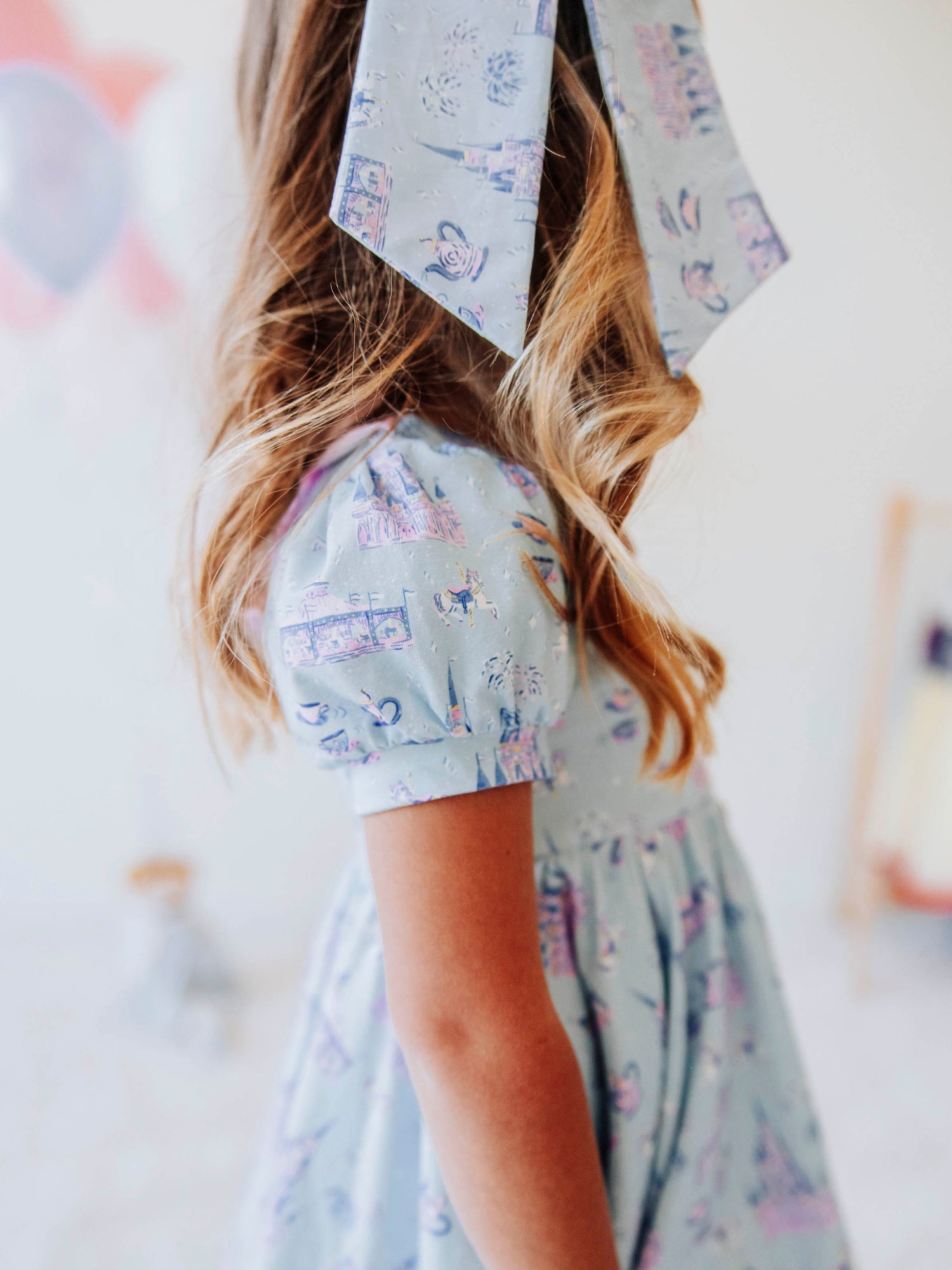 Bring a little fairytale charm to her day with our Most Magical Prim Dress! This enchanting dress features our exclusive Most Magical print — a whimsical pattern filled with castles, teacups, and dreamy pastel details. Designed with a sweet button-down front, short puff sleeves, and a full twirl skirt trimmed in pink polka dots, it’s perfect for playdates, park adventures, and magical memories.