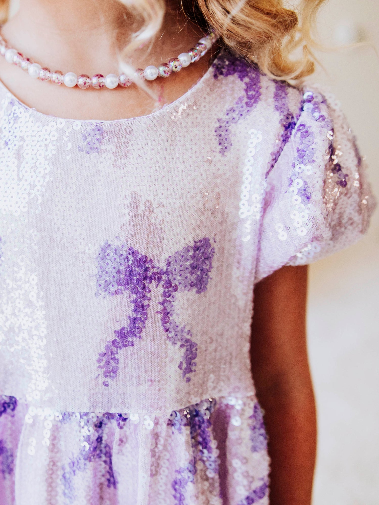 Let her sparkle and shine in our Lavender Sequin Bow Dress, a dazzling piece made for twirls, parties, and magical memories! Designed with shimmering lavender sequins and dainty bow details throughout, this girls’ sequin party dress captures the perfect mix of sweetness and sparkle.
The soft interior lining keeps her comfortable, while the puff sleeves and gathered skirt add a touch of classic charm. Perfect party dress, holiday dress and sparkle dress for any occasion! 