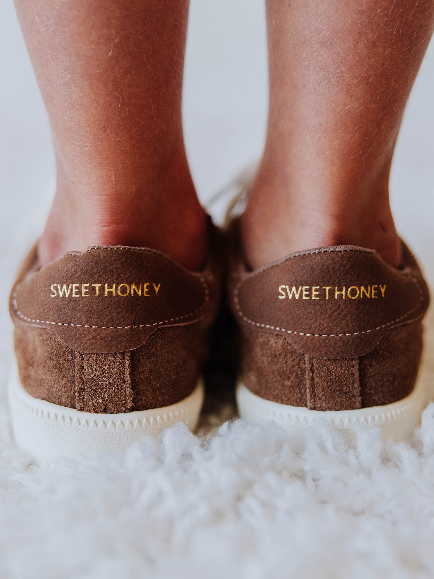 Brown mocha colored suede sneakers with SWEETHONEY stamped on the heel in gold.