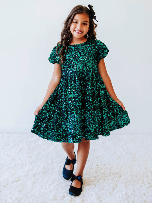 Make her holiday sparkle in our girls’ emerald green sequin dress, designed for festive celebrations, special occasions, and twirl-worthy moments. This stunning sparkle party dress for girls features an allover layer of shimmering green sequins that catch the light from every angle. With a soft interior lining and comfortable puff sleeves, it’s as cozy as it is glamorous.
Perfect for Christmas parties, family photos, and holiday events.