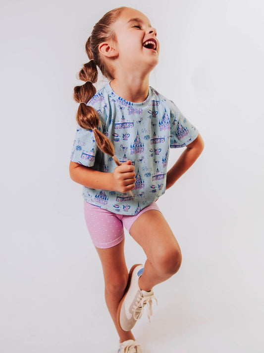 Serve up style and fun with our girls’ “Most Magical” active set, designed for comfort, movement, and everyday play. This adorable sleeveless dress features a whimsical print inspired by magical castles, carousels, and fairy-tale adventures — perfect for little dreamers who love both sports and sparkle. The lightweight, stretchy performance fabric keeps her cool and comfortable from the court to the playground, while the flowy shirt design and active shorts allows for easy twirls and active fun.