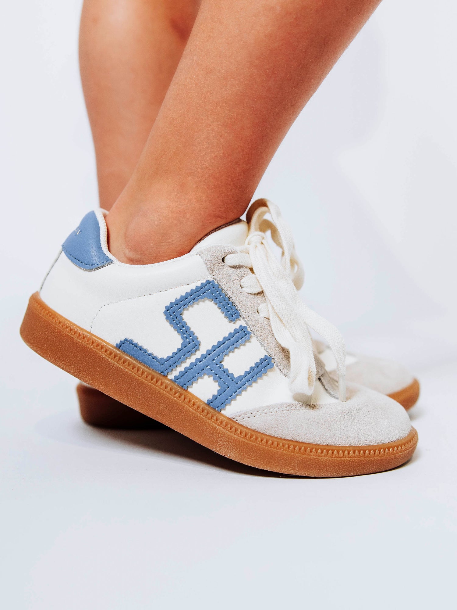 Fresh, fun, and full of SweetHoney style — our Signature Sneakers in dusty blue and white are the perfect mix of comfort and charm! Featuring our bold “SH” SweetHoney logo, soft suede accents, and durable gum soles, these boutique kids’ sneakers are designed for everyday adventures. Whether paired with twirl dresses or playtime outfits, they’re the ultimate blend of fashion and function for little trendsetters on the go.