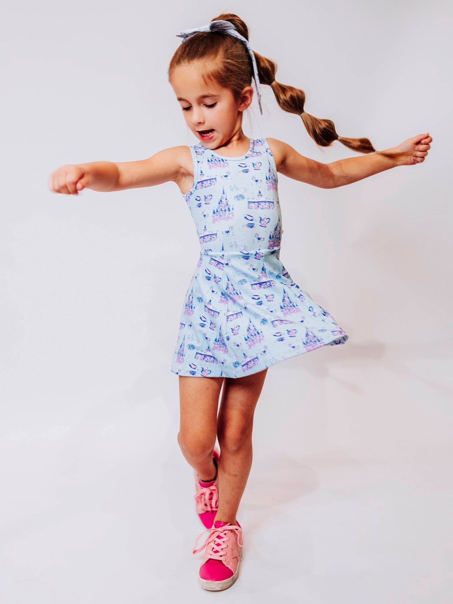 Serve up style and fun with our girls’ “Most Magical” tennis dress, designed for comfort, movement, and everyday play. This adorable sleeveless dress features a whimsical print inspired by magical castles, carousels, and fairy-tale adventures — perfect for little dreamers who love both sports and sparkle. The lightweight, stretchy performance fabric keeps her cool and comfortable from the court to the playground, while the flared skirt design allows for easy twirls and active fun.