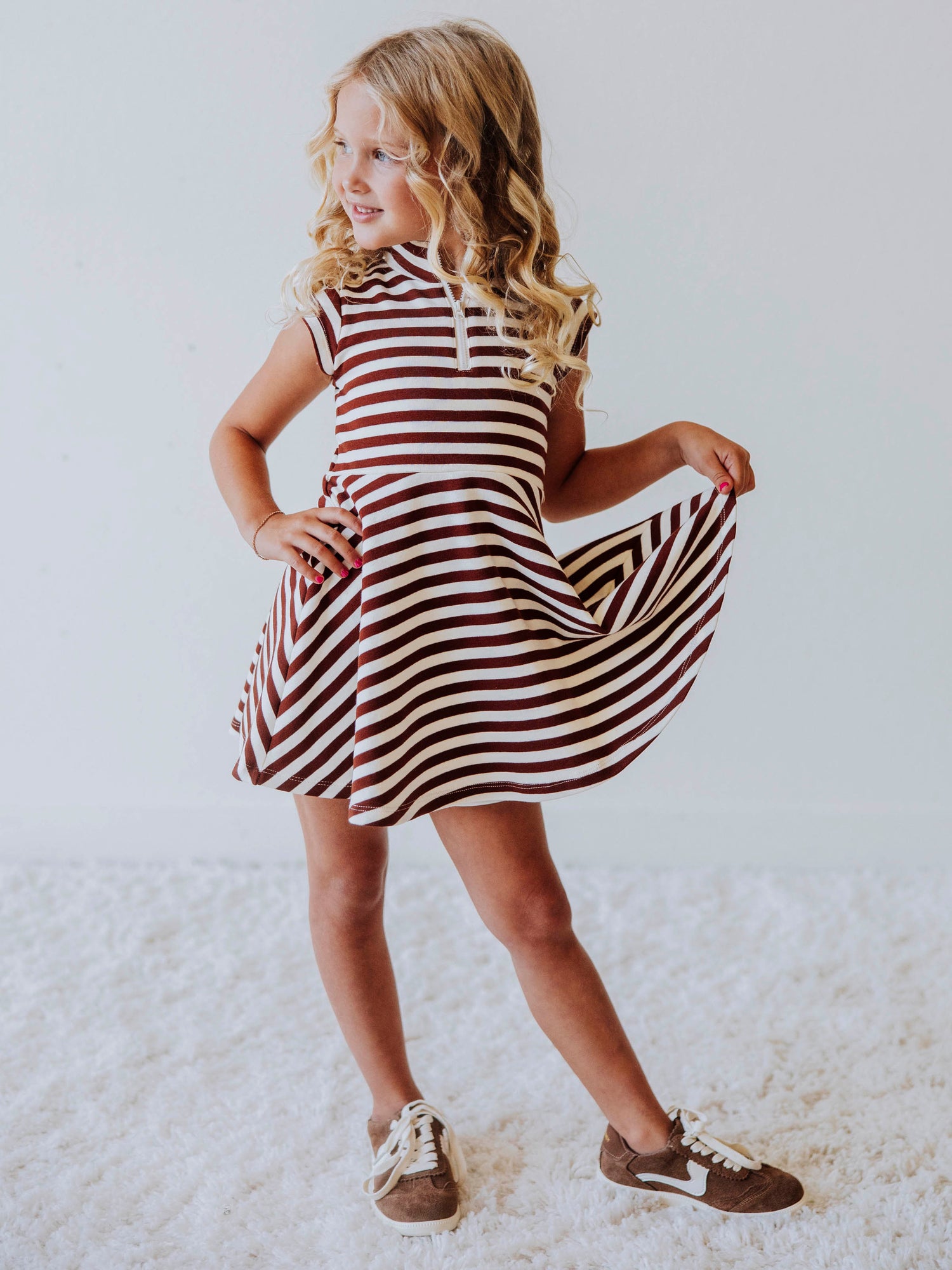 Model wearing a brown and ivory striped dress. Model is wearing brown shoes too. 