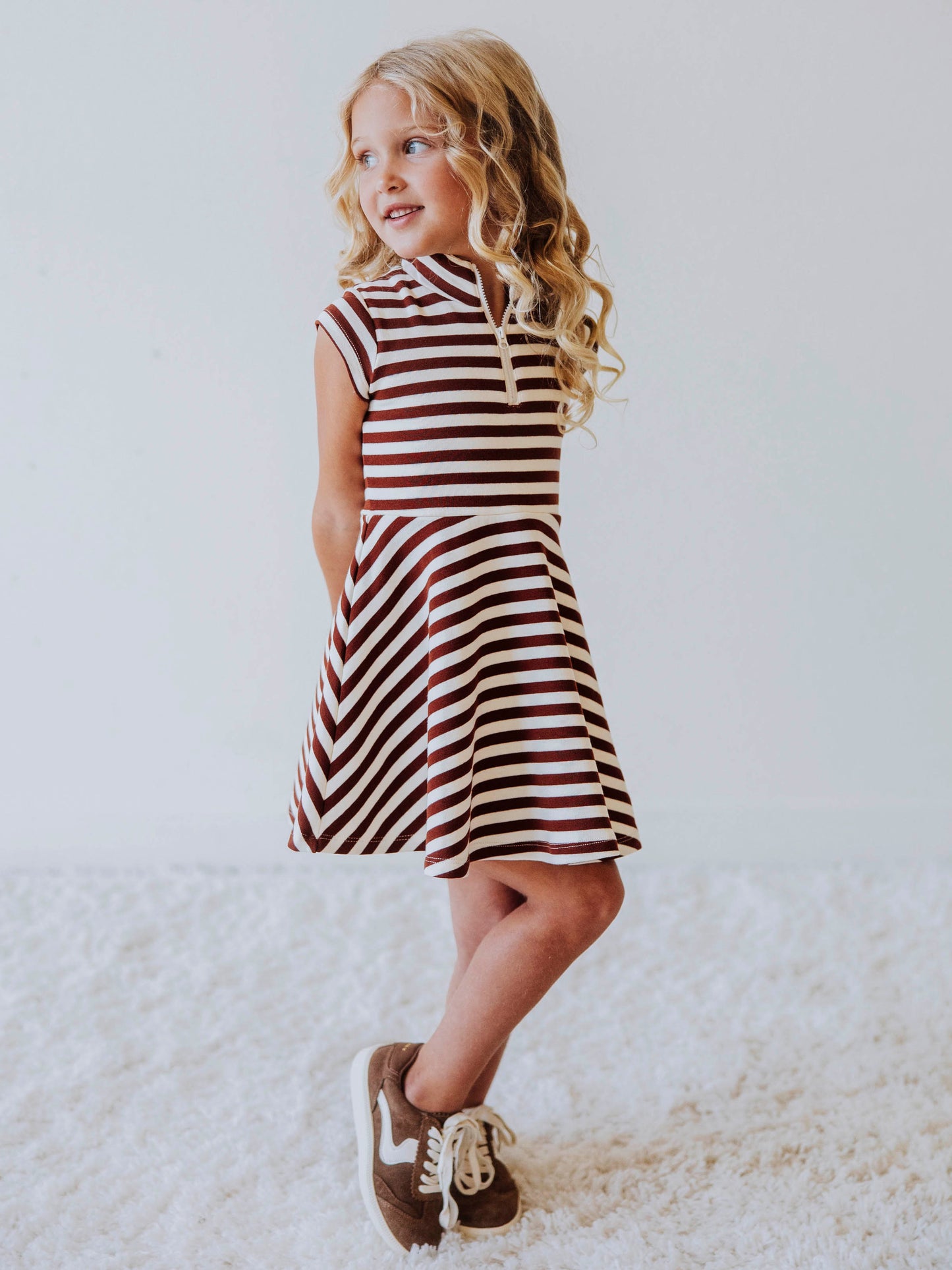 Model wearing a brown and ivory striped dress. Model is wearing brown shoes too. 