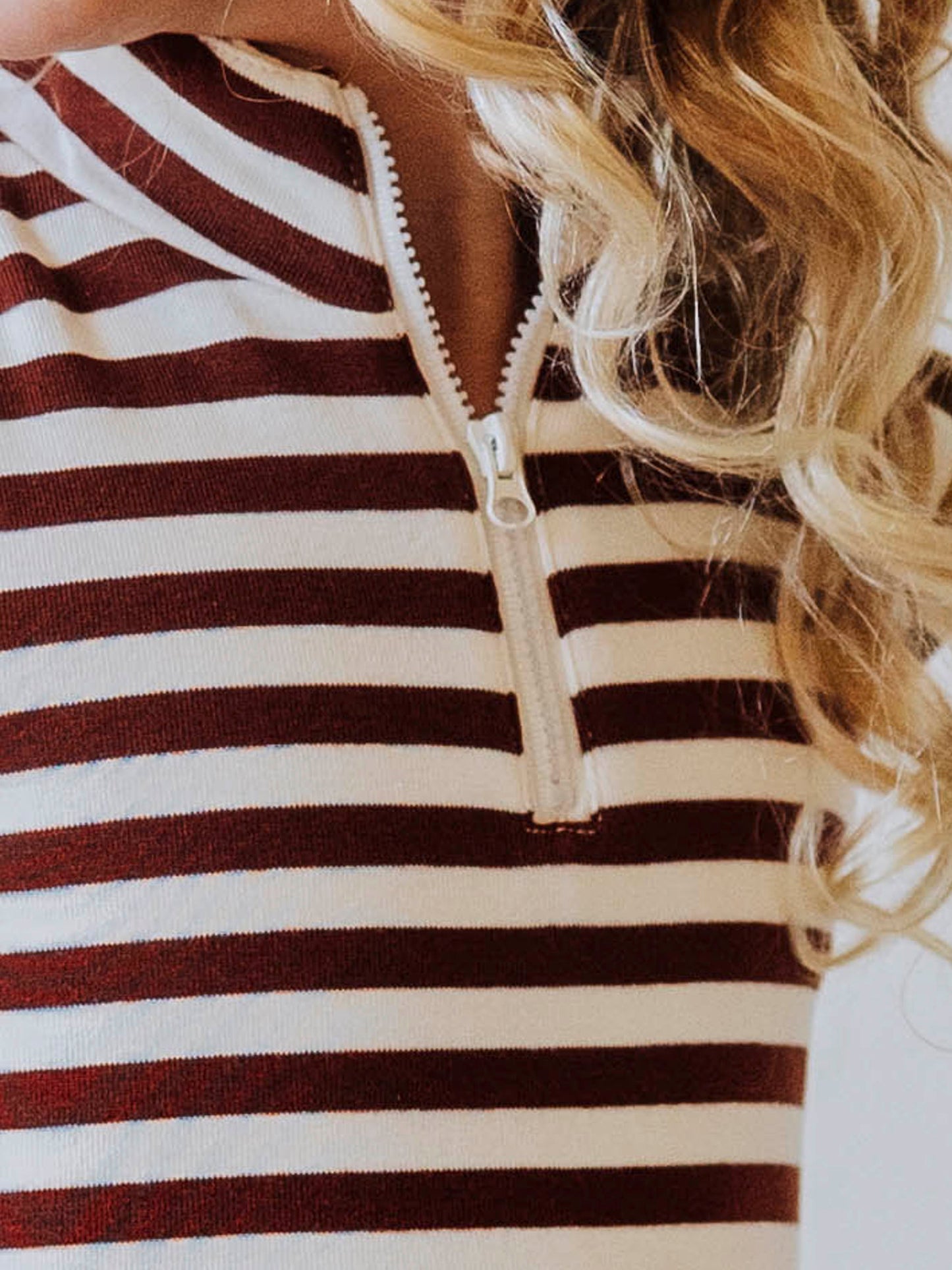 Model wearing a brown and ivory striped dress. Model is wearing brown shoes too. Up close picture of zipper on dress. 
